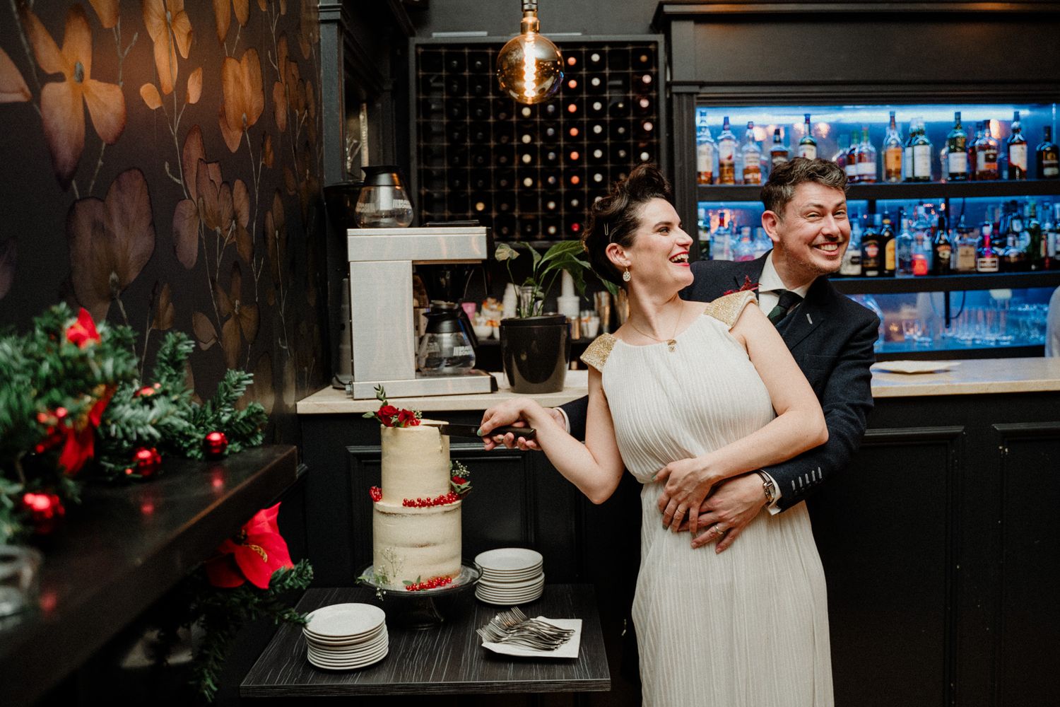 Modern wedding reception with city skyline views and red floral decorations.