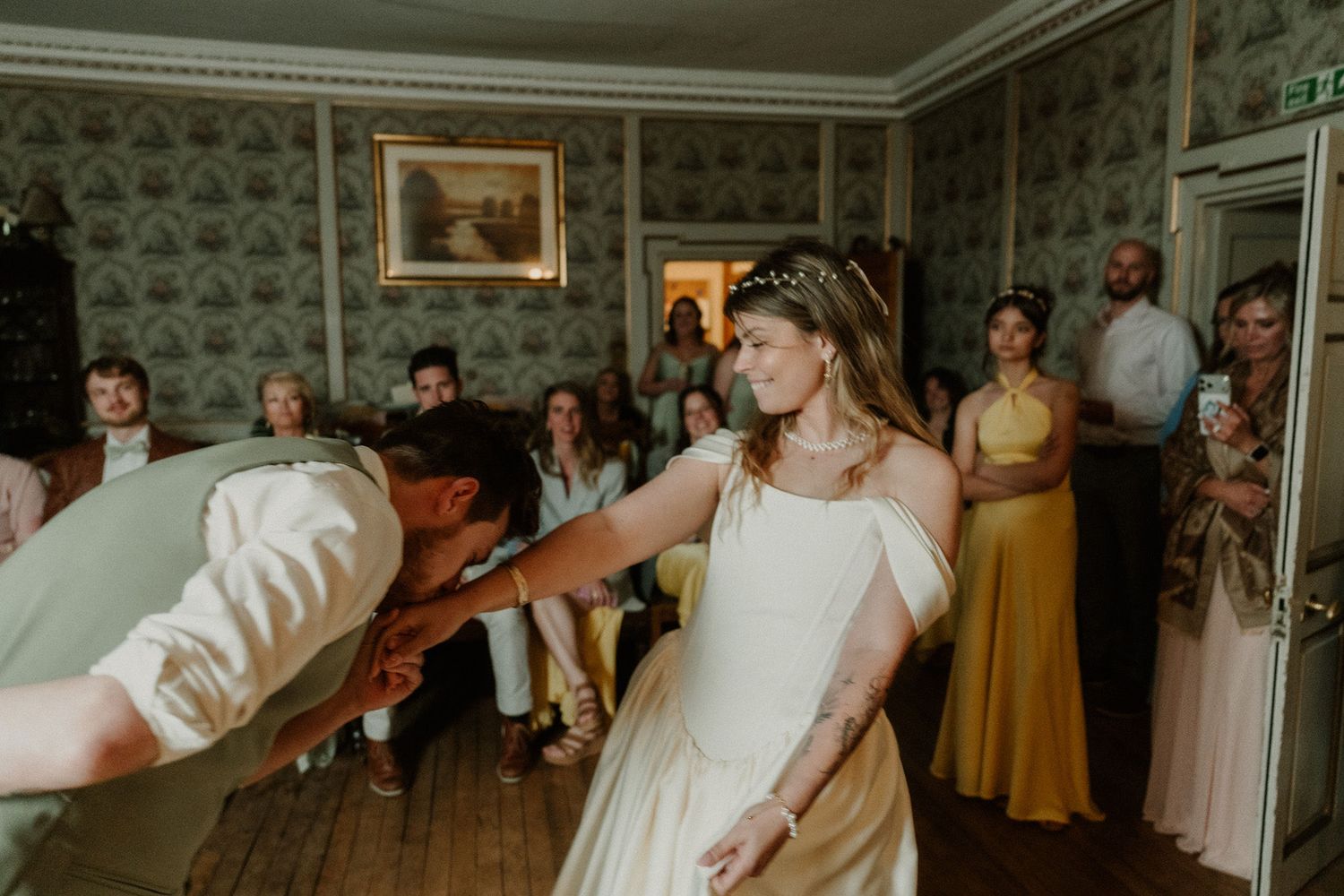 Bride in white gown dancing joyfully with guests watching at an elegant wedding reception.