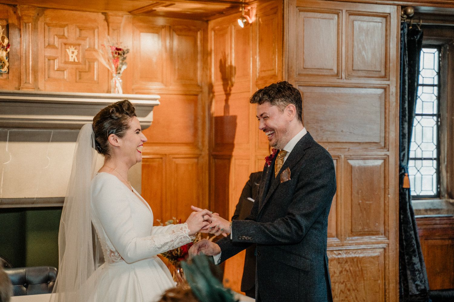 Wedding ceremony in an elegant wood-paneled room with warm ambient lighting.
