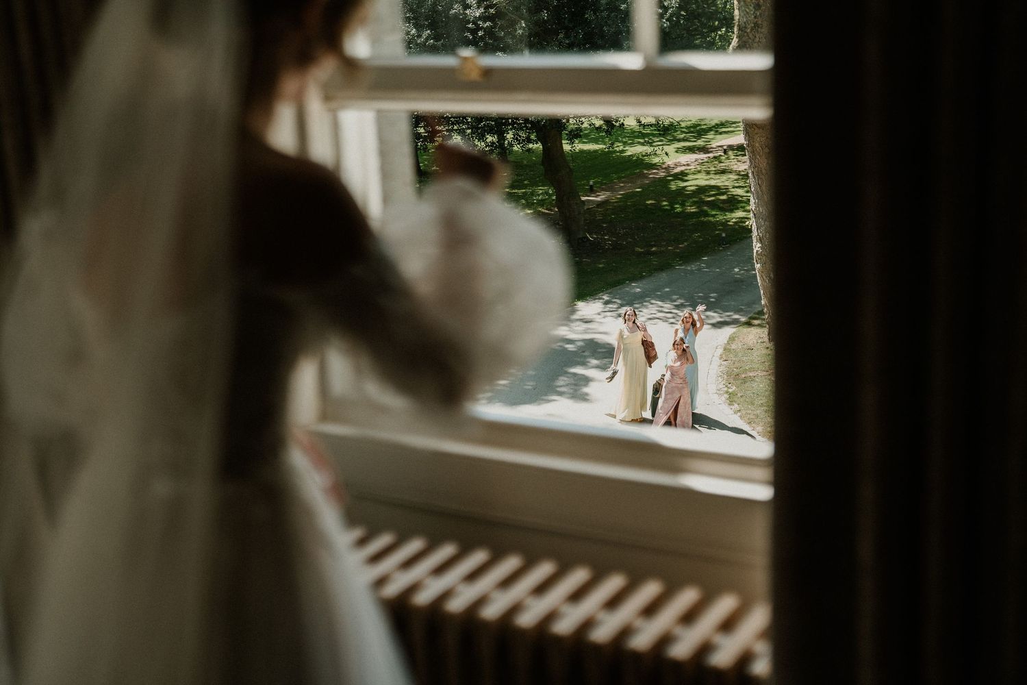 View through window showing outdoor wedding venue with greenery.