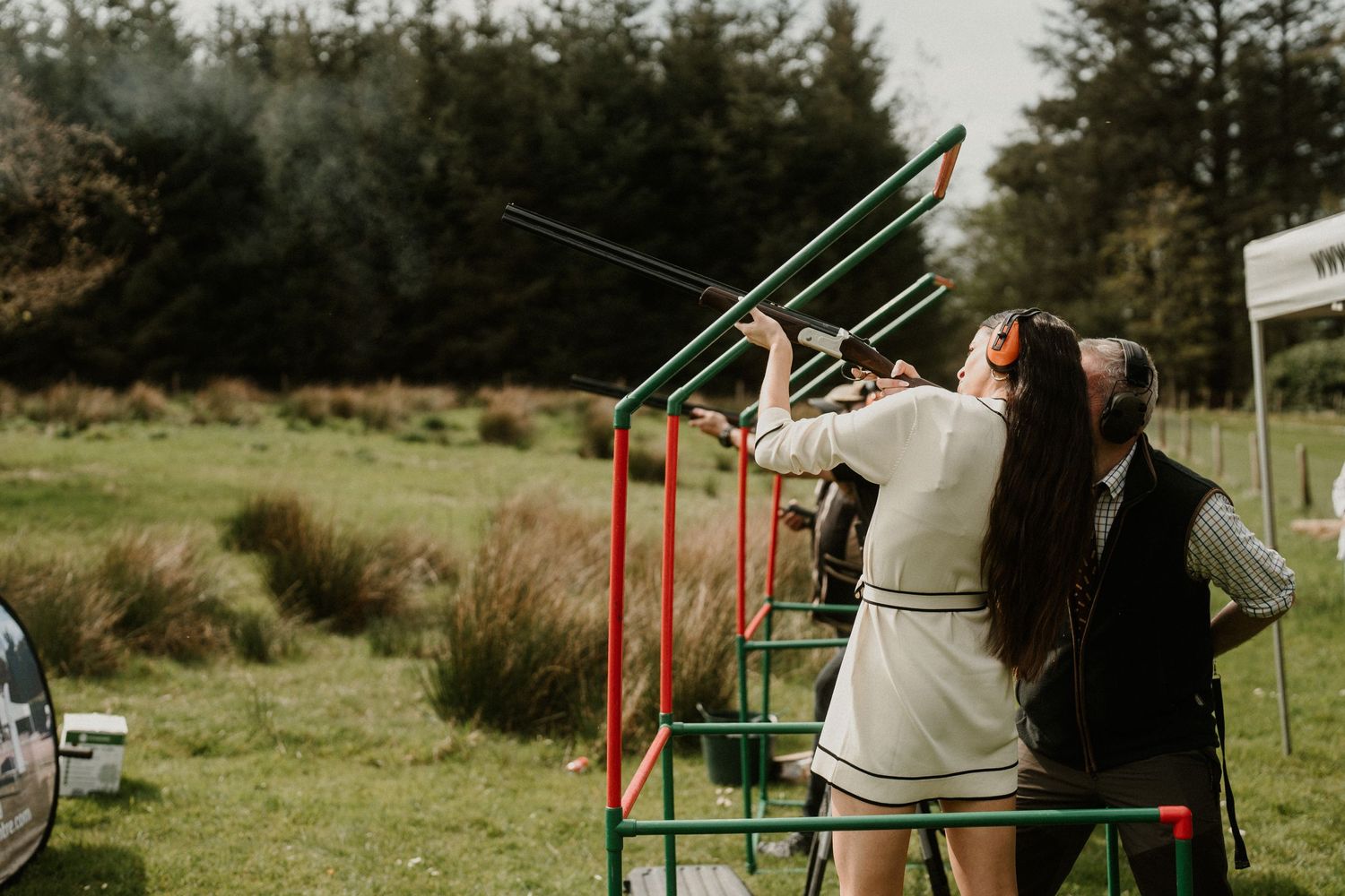 People practicing archery outdoors with targets set up in a grassy field.