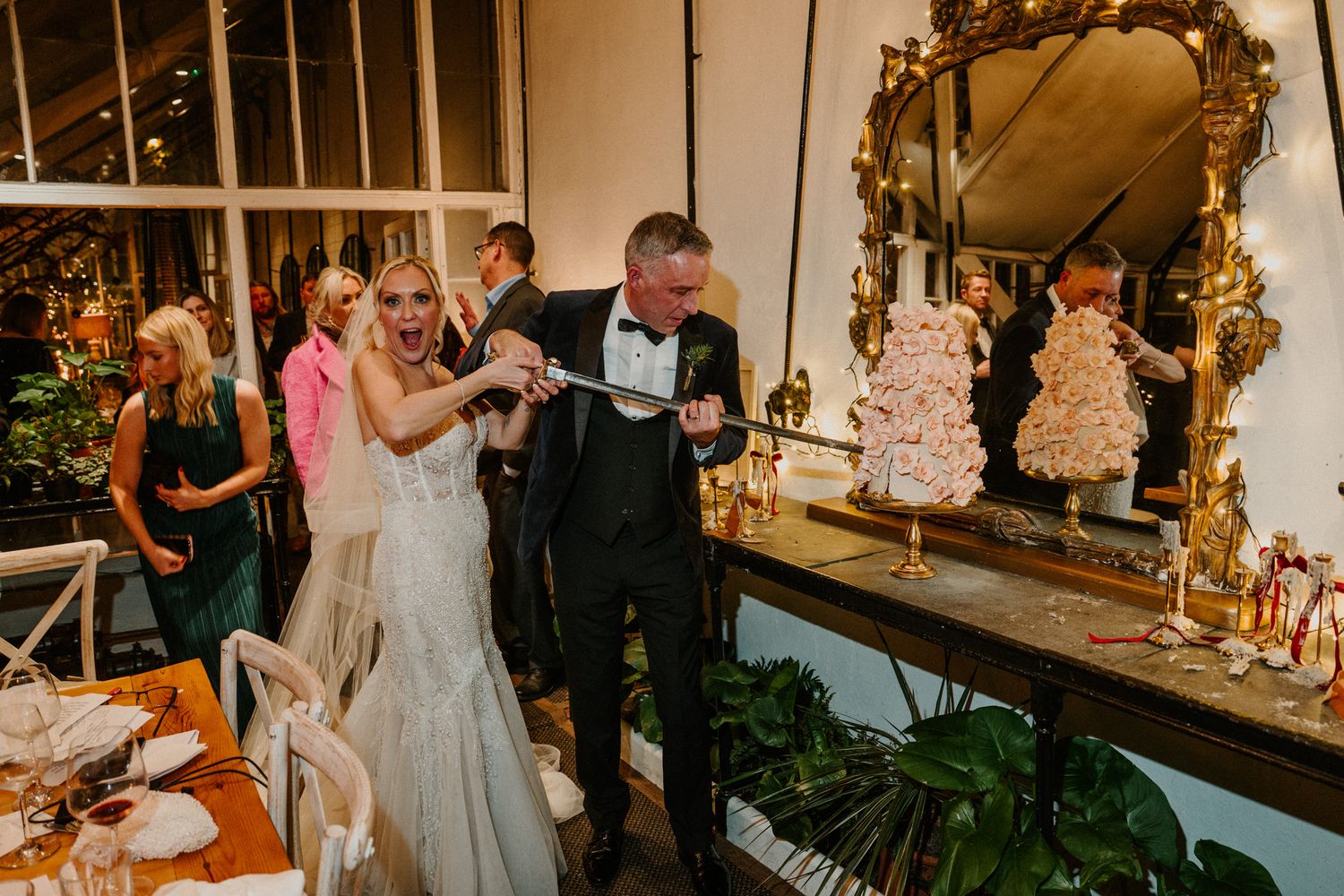 Wedding celebration in a beautifully decorated venue with vintage mirrors and greenery.