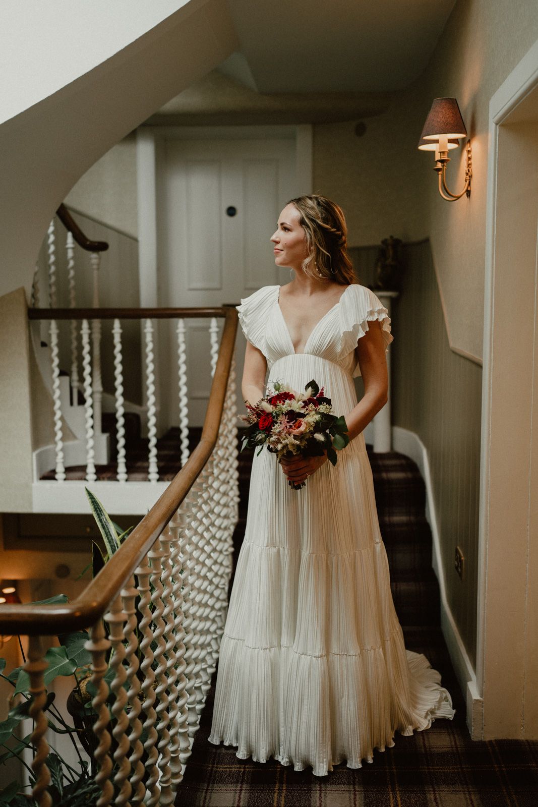 Flowing white wedding dress captured in artistic angles on staircase.