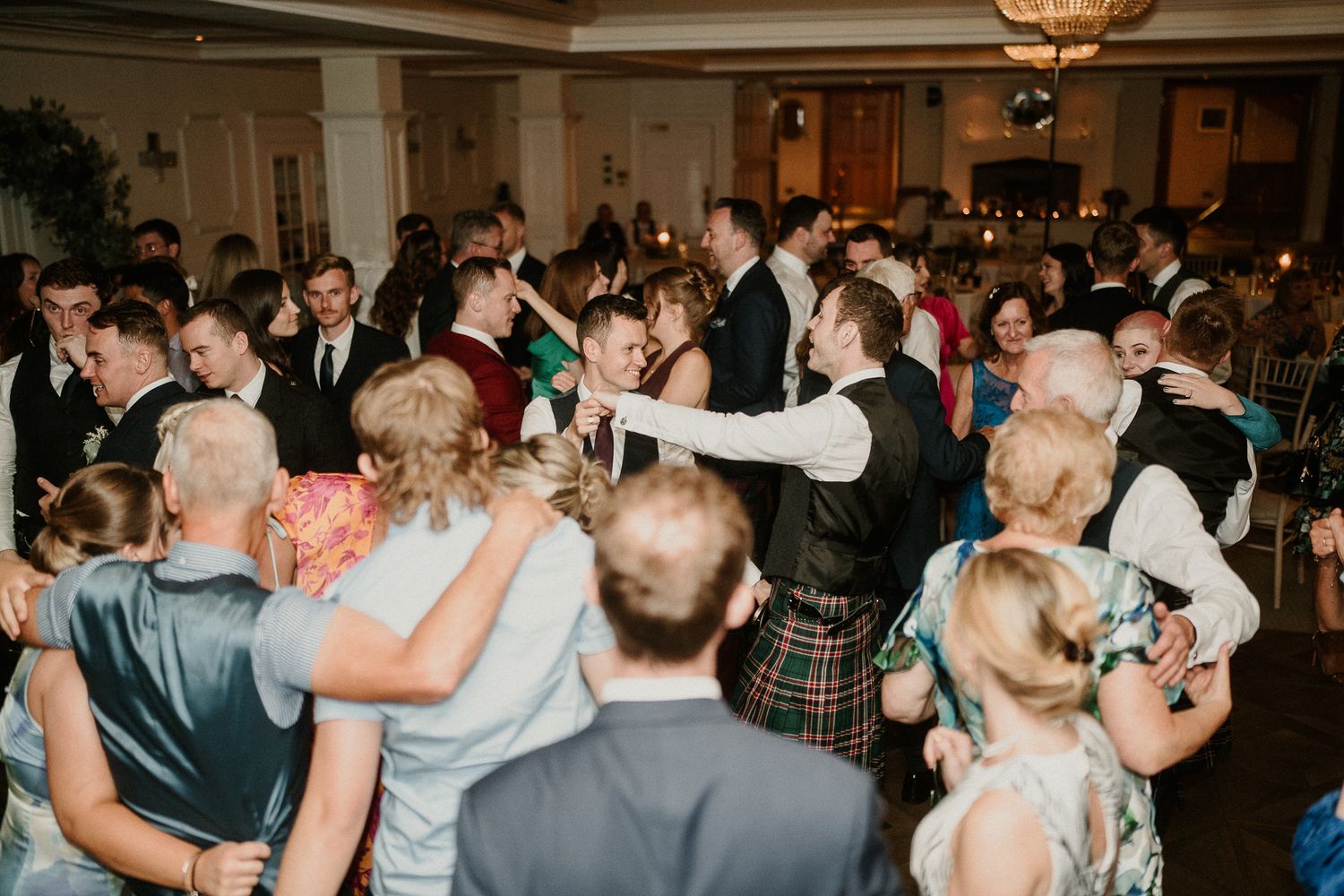 Crowded wedding dance floor filled with guests enjoying traditional Scottish celebration.