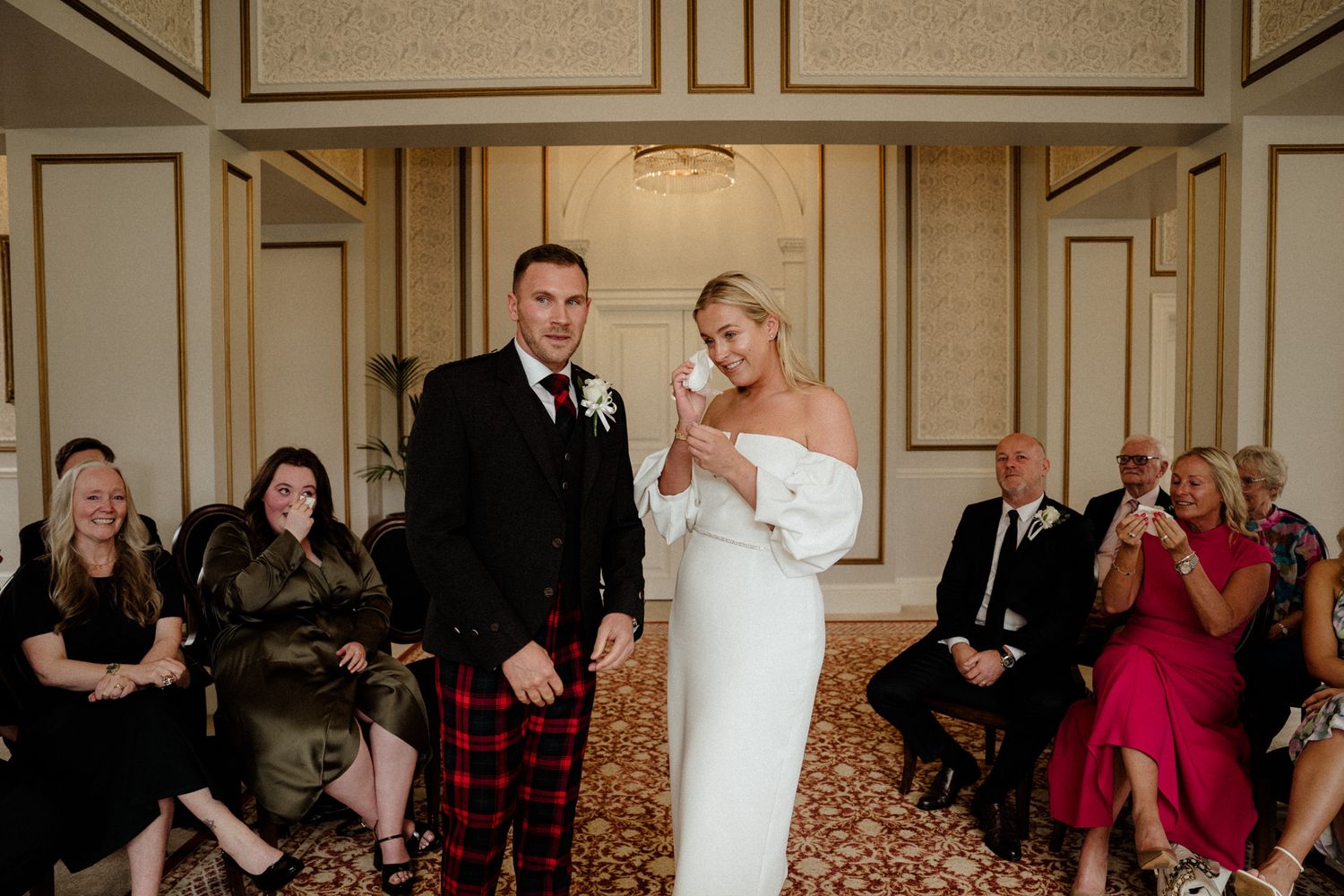 Wedding celebration in an elegant ballroom with guests watching the couple's special moment.