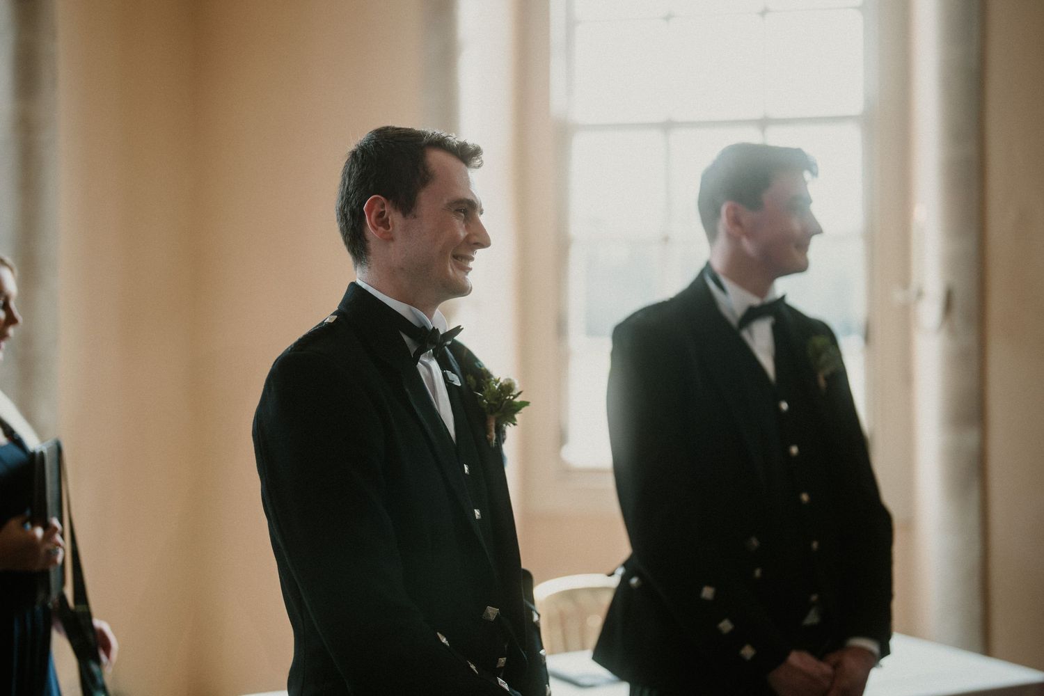 Wedding party members in formal black attire gathered in an elegant indoor setting.