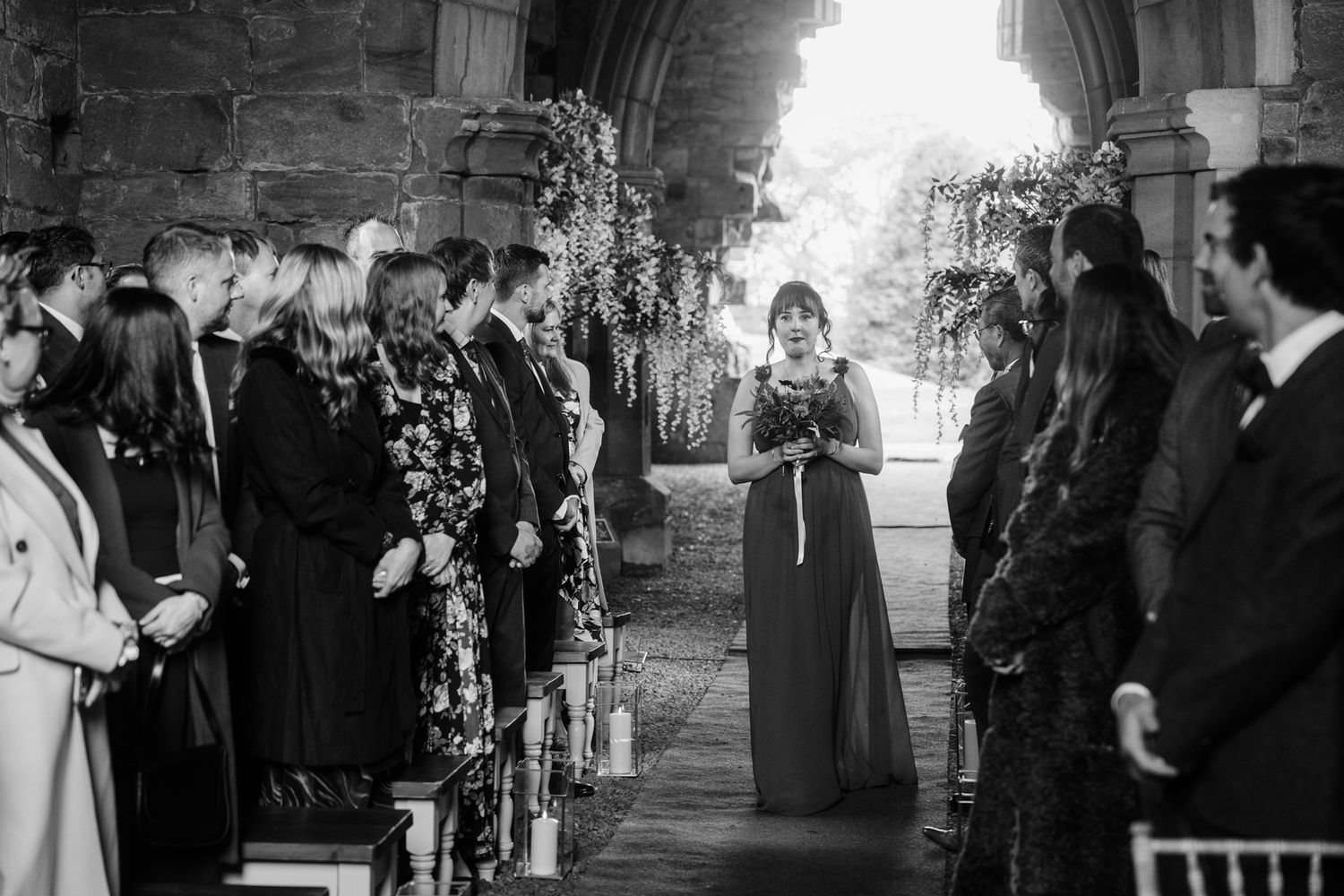Black and white photo captures wedding ceremony moments in historic church setting.