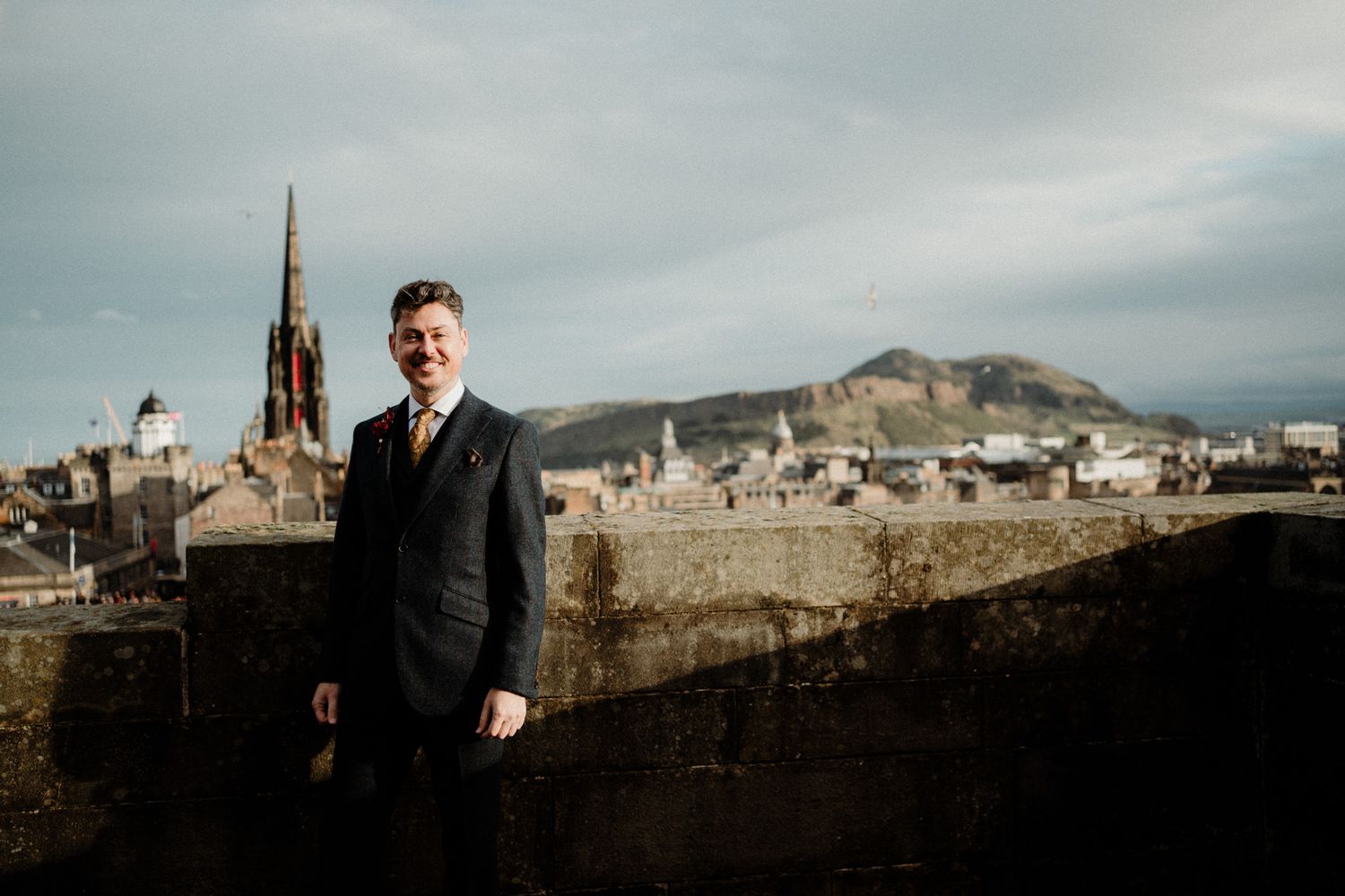 Panoramic view of Edinburgh's historic skyline with castle and monuments.