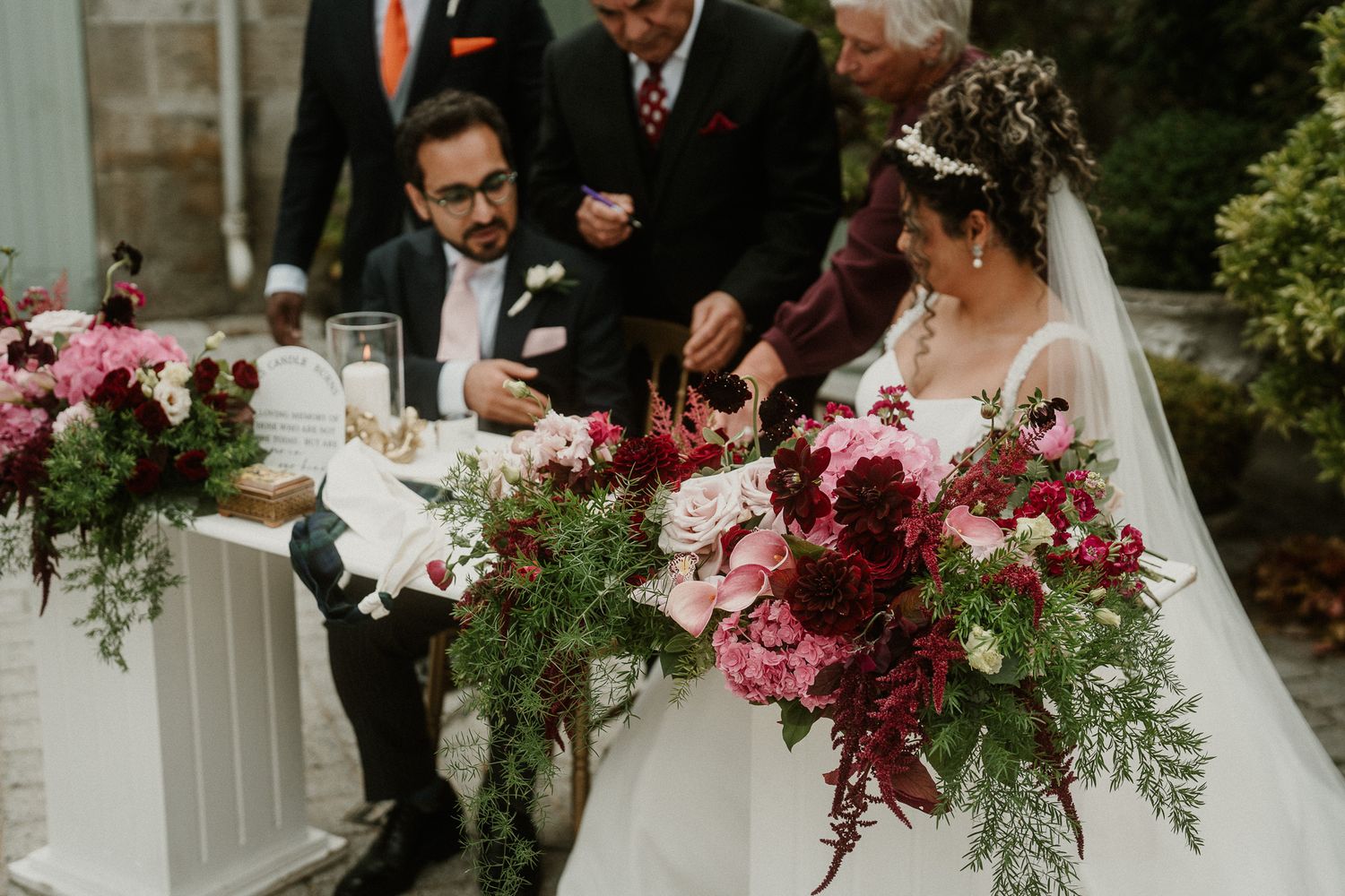 Wedding ceremony celebration on an elegant stone terrace with floral decorations.