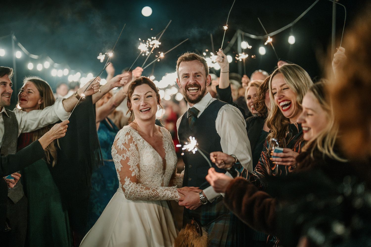 Wedding celebration with sparklers creating a magical atmosphere as guests cheer.