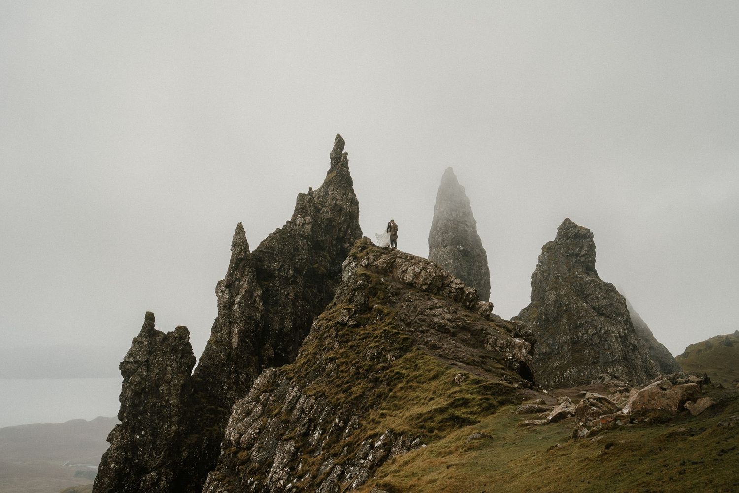 Dramatic rocky cliffs and spires rise from misty Scottish highlands at the Old Man of Storr on Isle of Skye.
