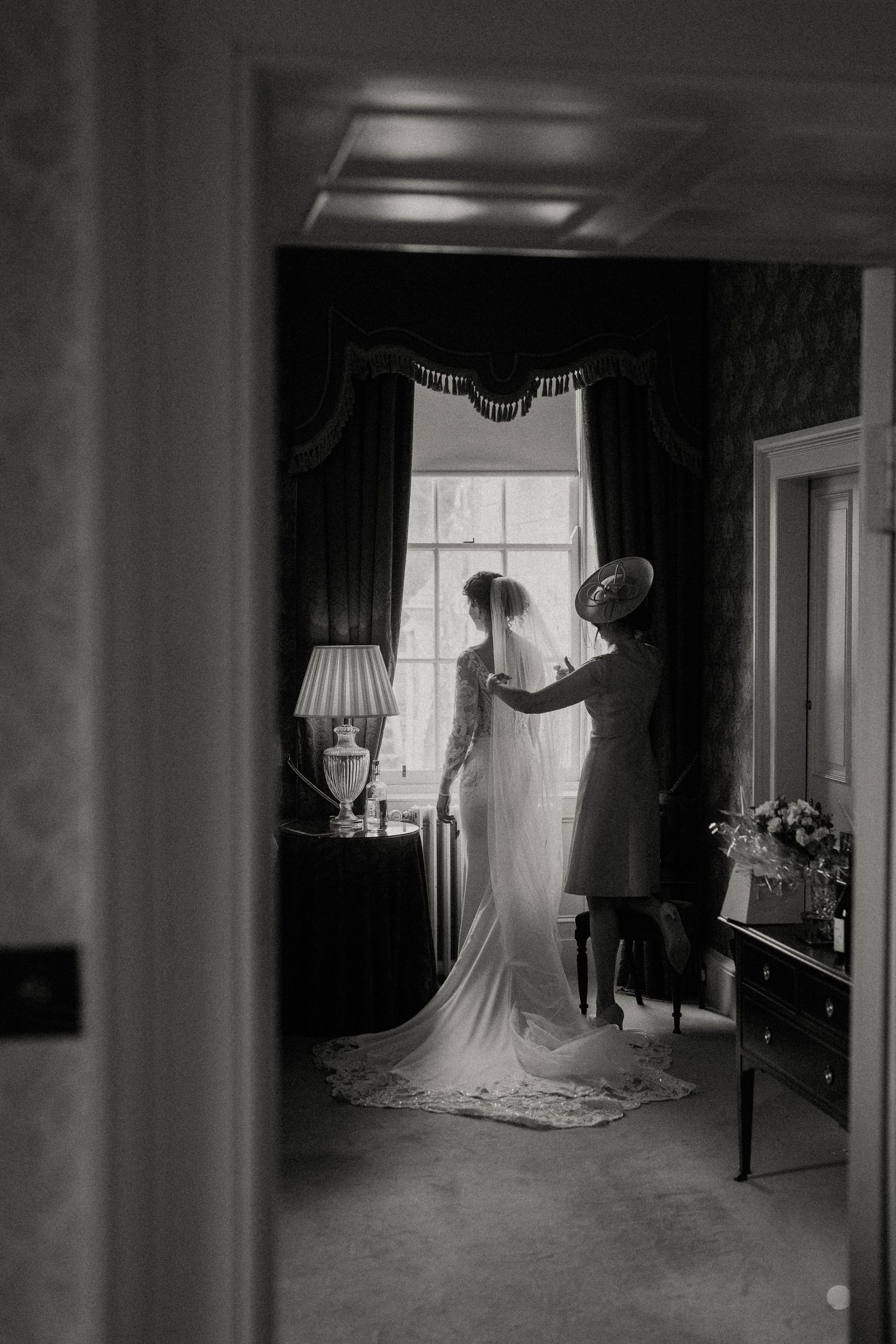 A series of black and white photos showing the silhouette of a bride in a wedding dress against a window in a dark room.
