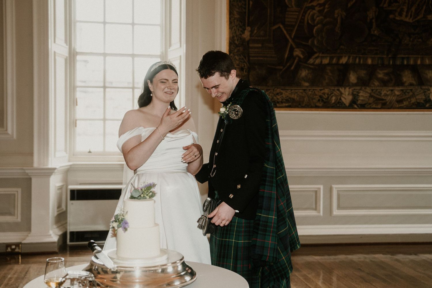 A wedding celebration in a bright formal room with white decor and Scottish tartan details.