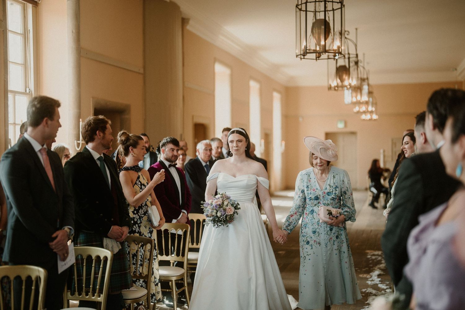 Wedding ceremony space with warm lighting from vintage-style chandeliers.