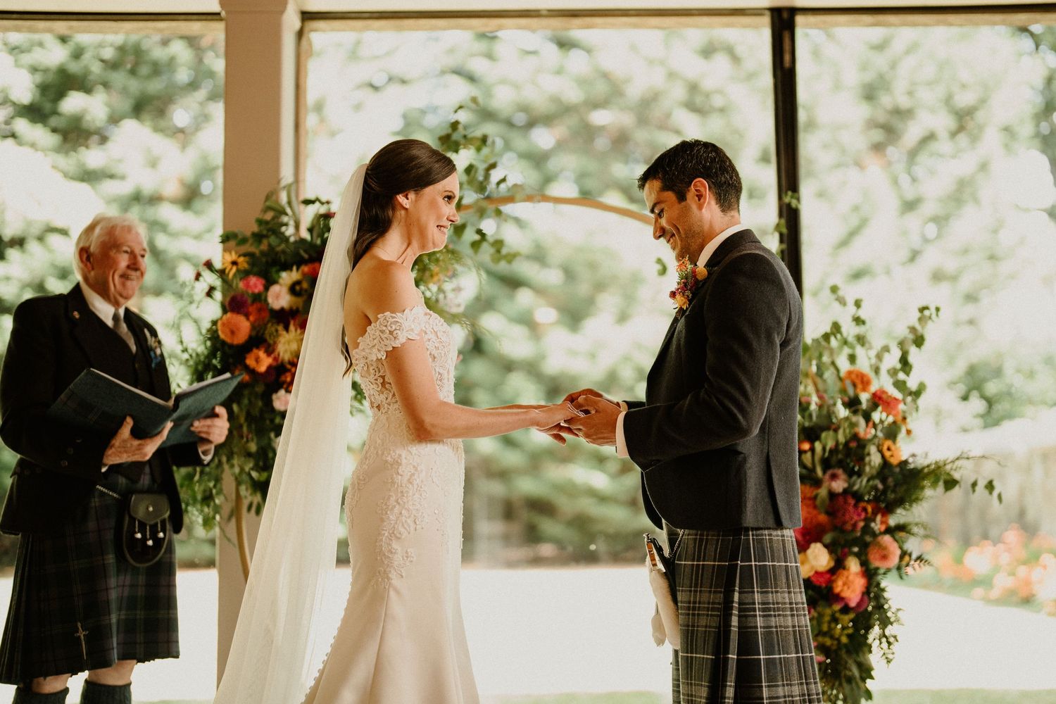 Intimate wedding ceremony moments captured in sunlit indoor venue with floral decorations.