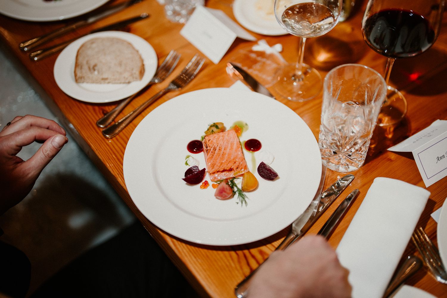 Fine dining place settings with white plates and crystal glassware on an elegantly set table.