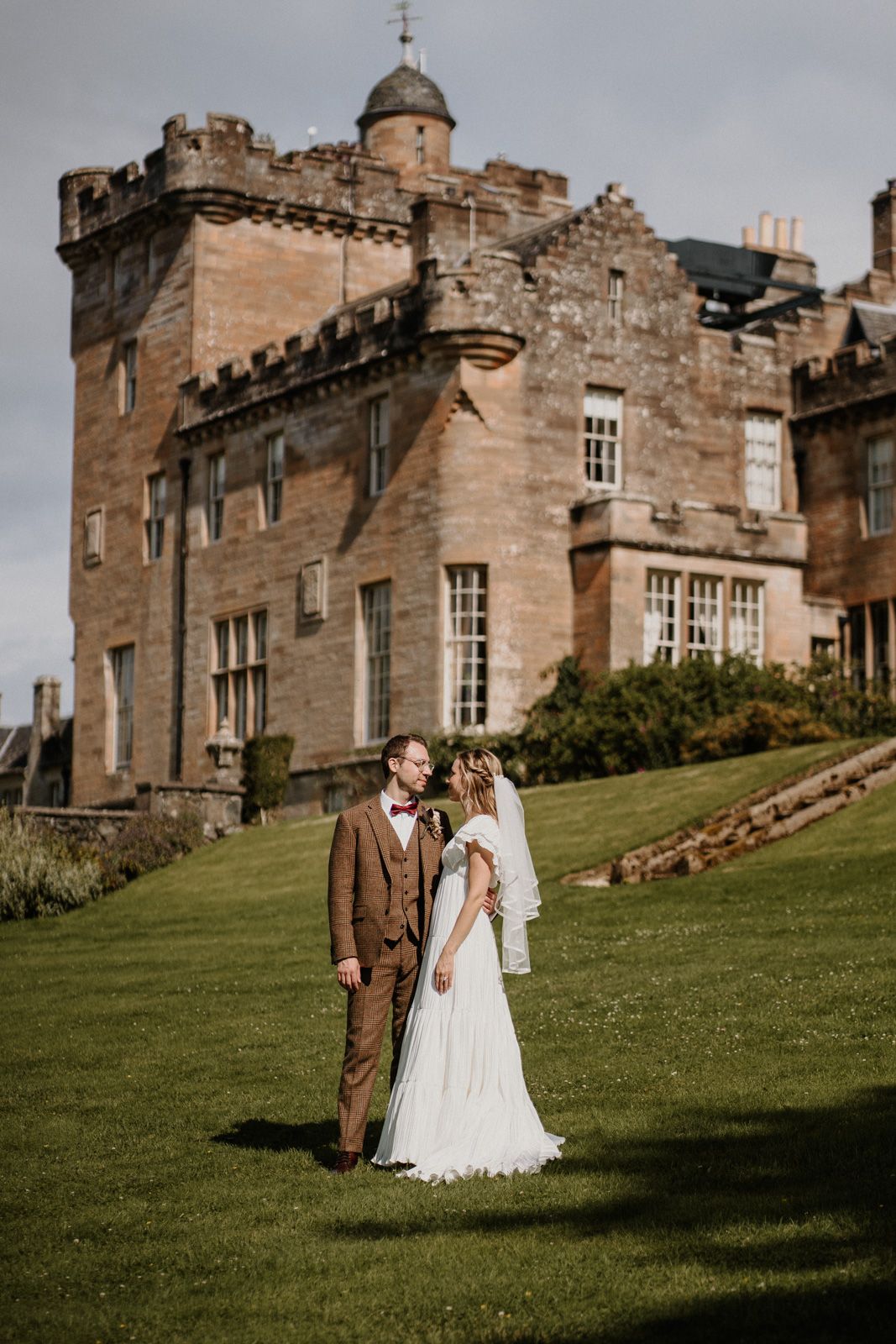 A stunning castle wedding venue with stone architecture and manicured lawns.