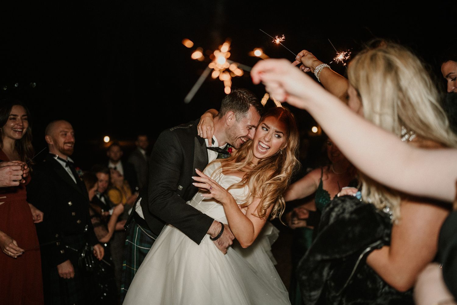 Silhouettes of party guests dancing and celebrating in a dimly lit venue.