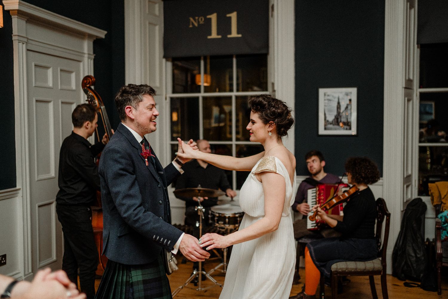 Wedding guests dance and celebrate during an evening reception at an elegant indoor venue.