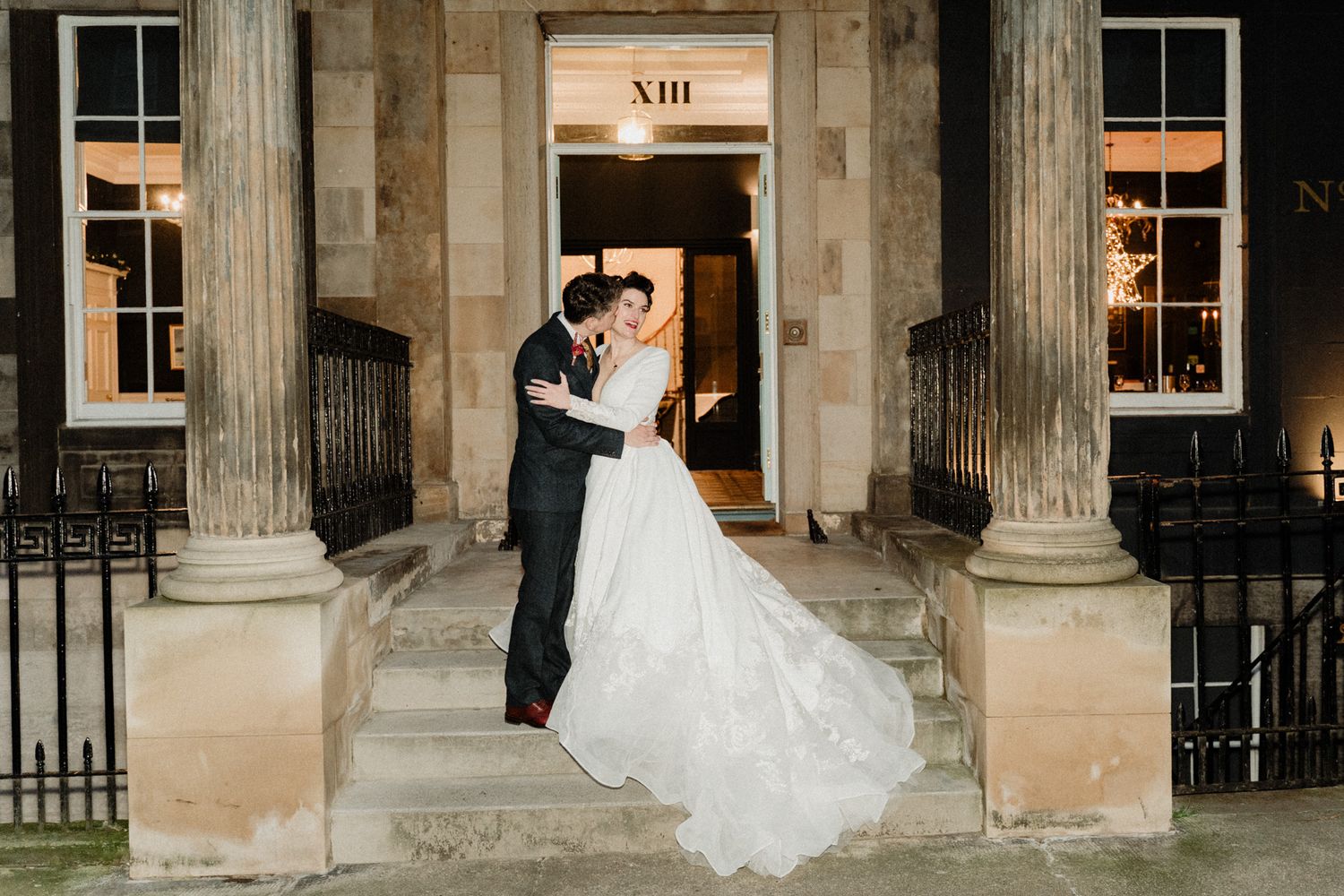 Wedding photography session in front of a classical building with stone columns.