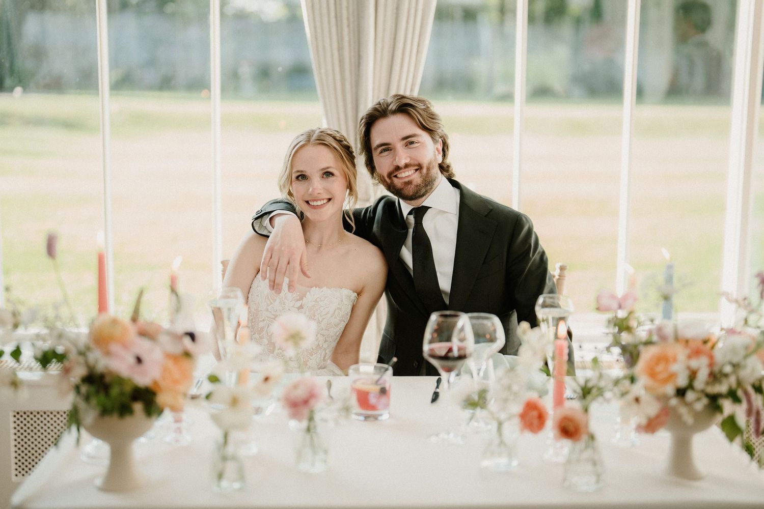 Wedding reception venue decorated with pink and coral floral centerpieces.