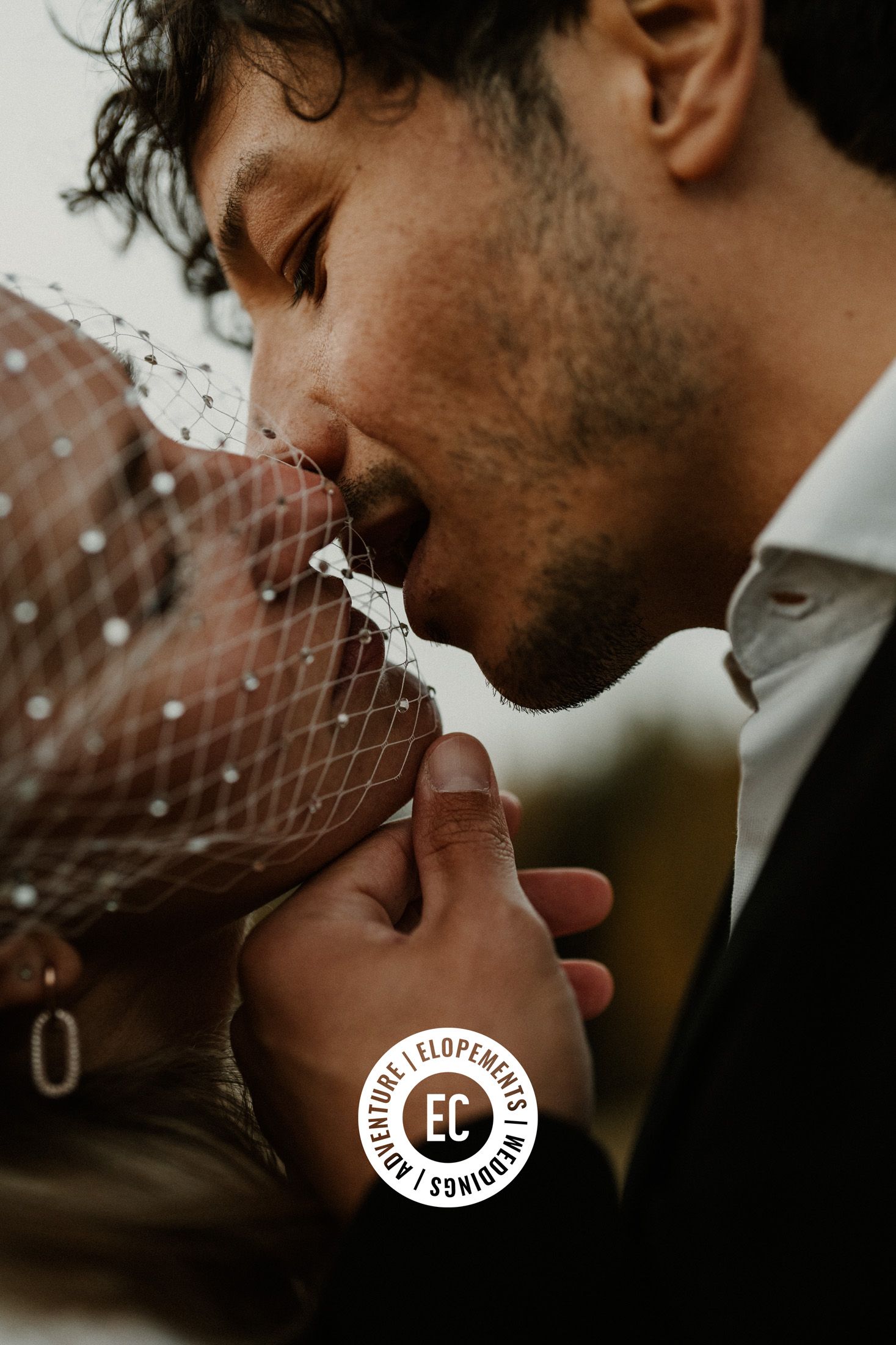 Intimate close-up portrait showing delicate details of a wedding veil and formal attire.