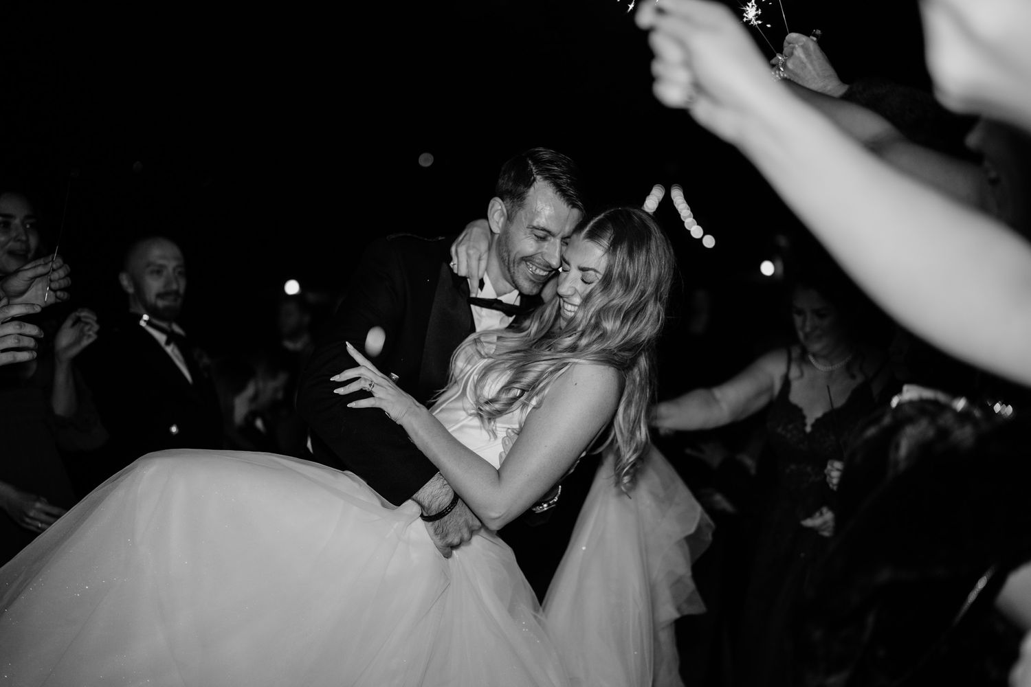 Black and white photos of wedding guests dancing and celebrating at a reception party.