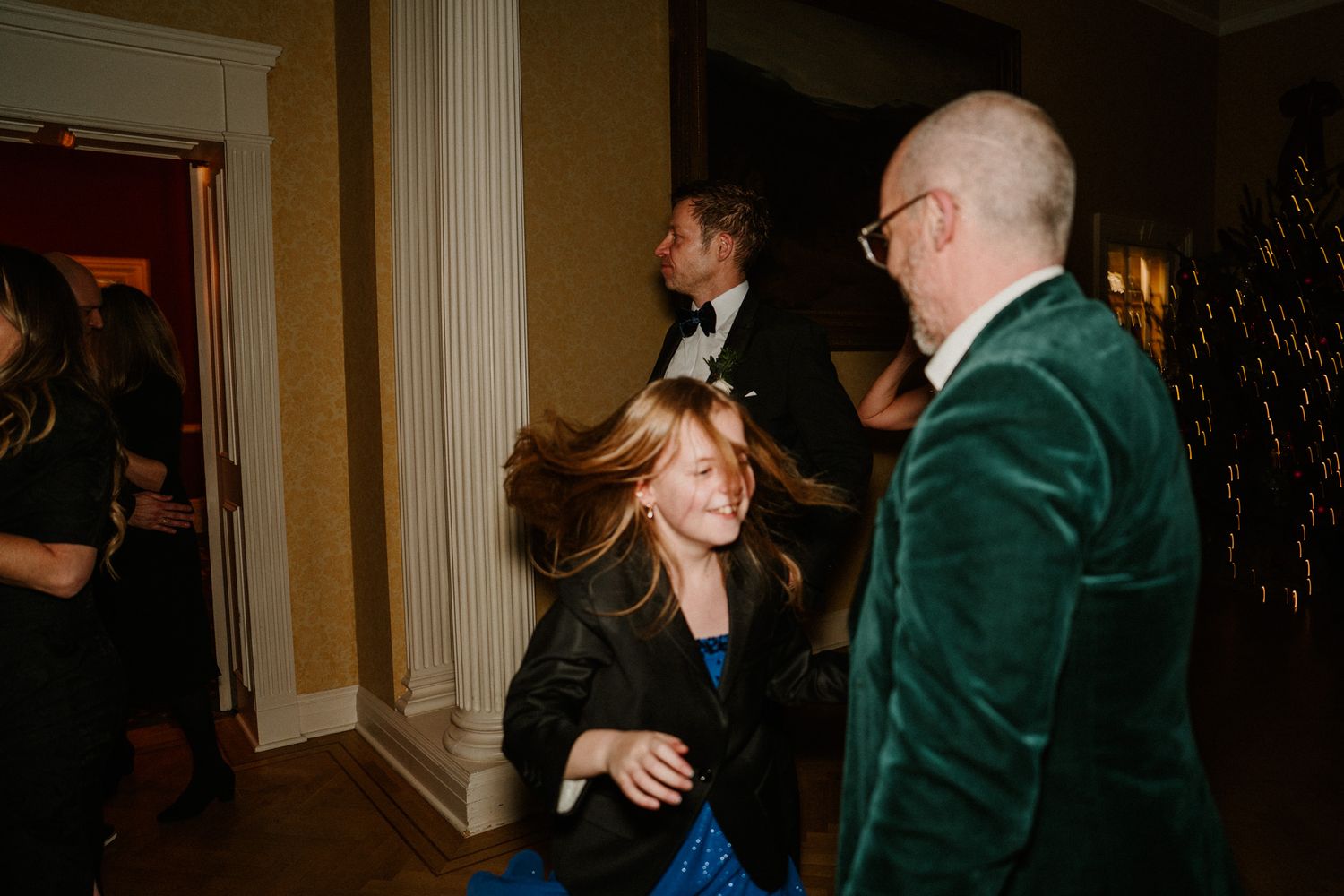 Guests in formal attire dance and celebrate at an elegant wedding reception.