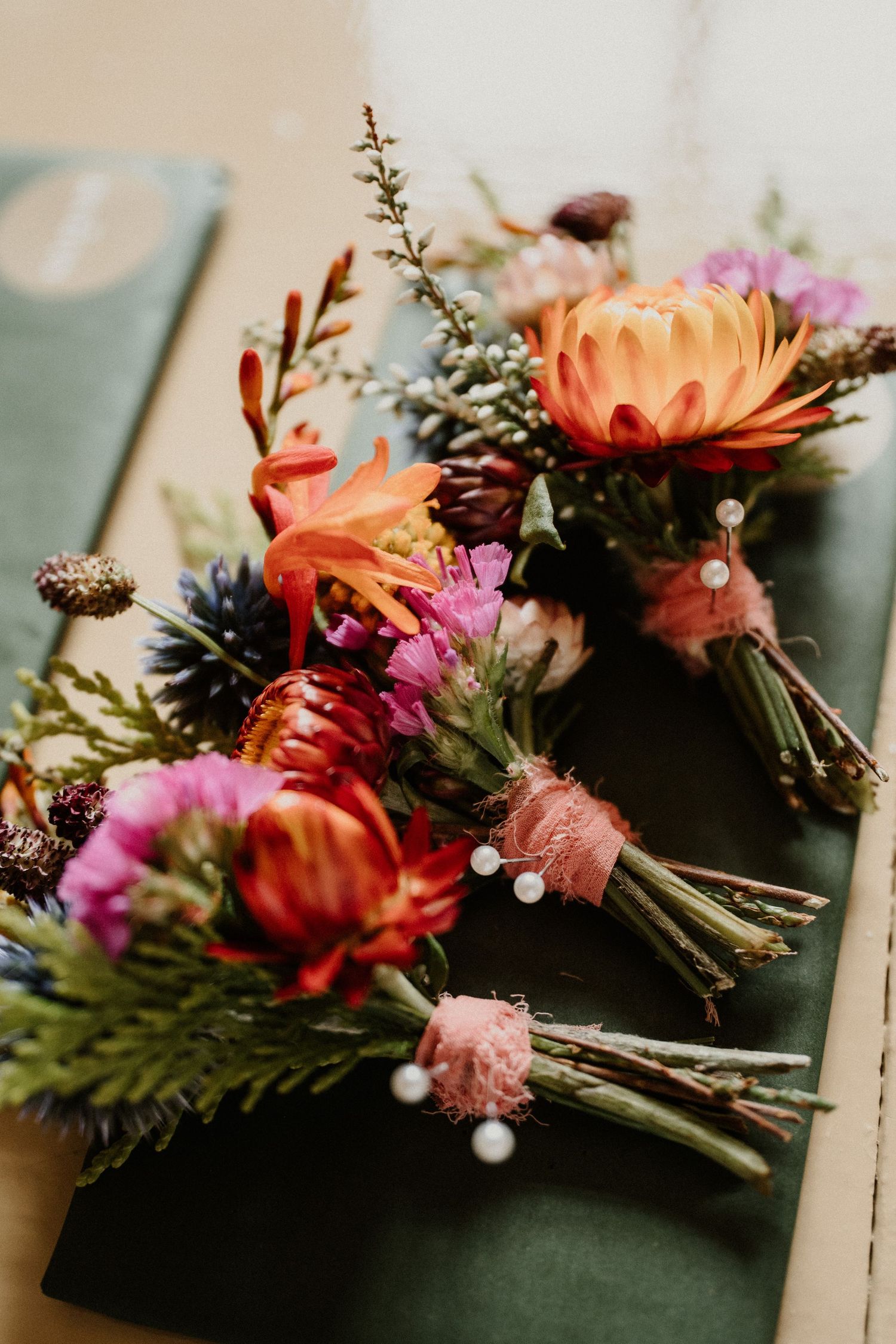 Colorful floral arrangement with pink and orange blooms on a dark surface.