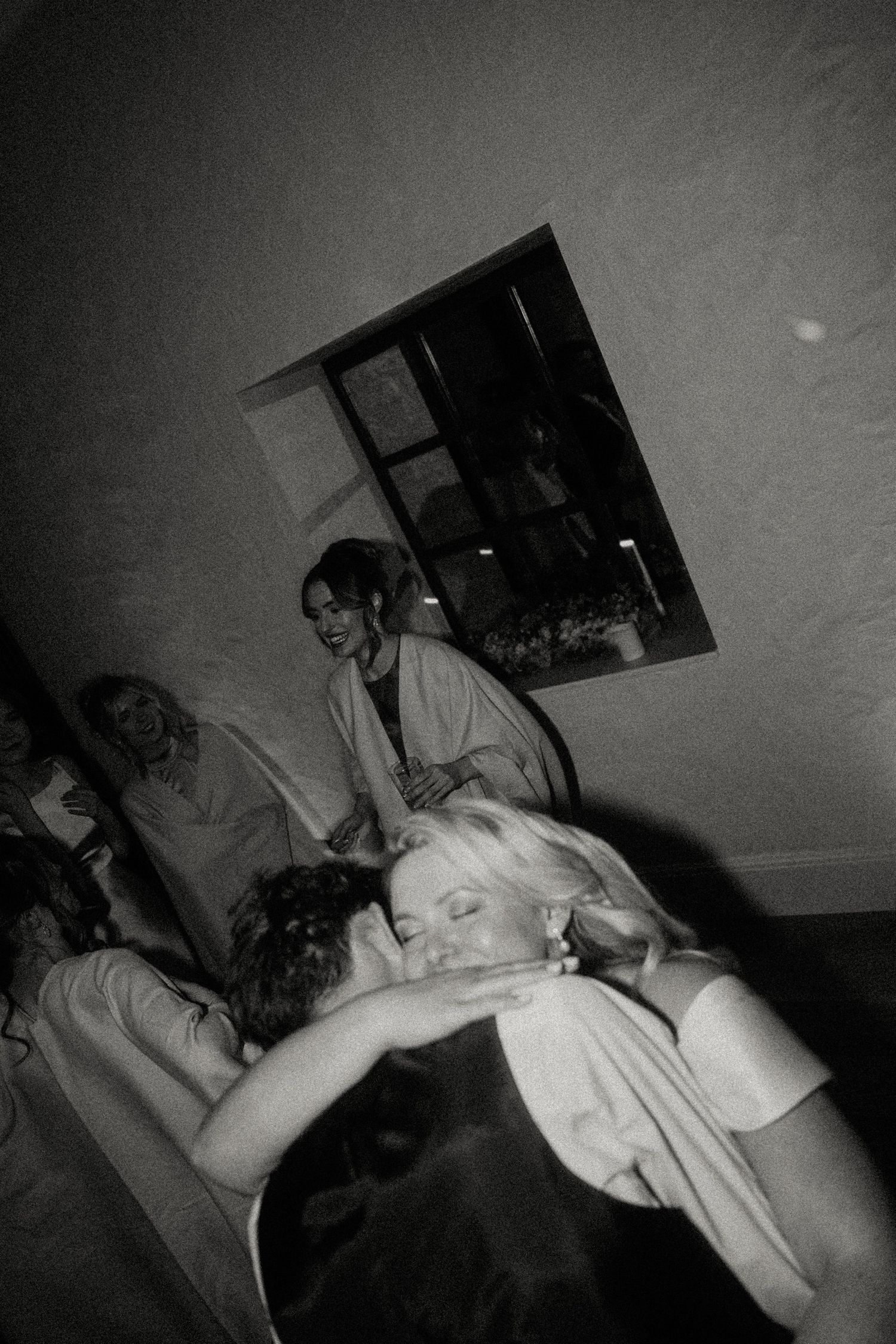 Black and white candid party photo showing energetic dance floor moments.