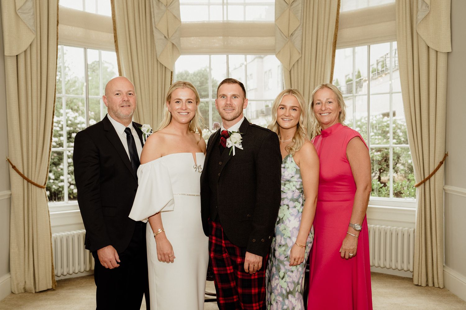 Elegant wedding reception in a sunlit room with cream curtains and formal decor.