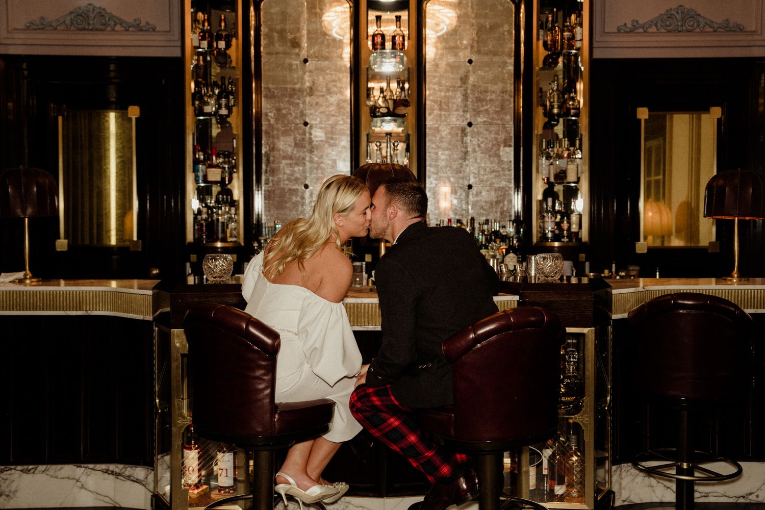 Dimly lit wedding reception venue with ornate gold architectural details and mood lighting.