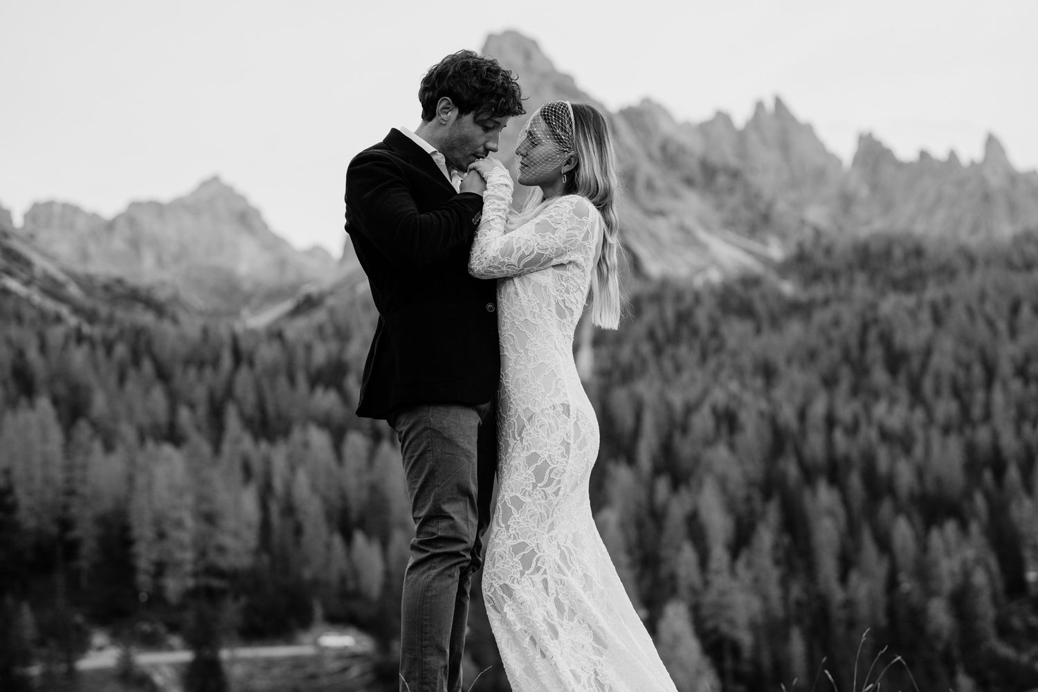 Romantic mountain wedding portrait with dramatic Dolomites peaks in the background.