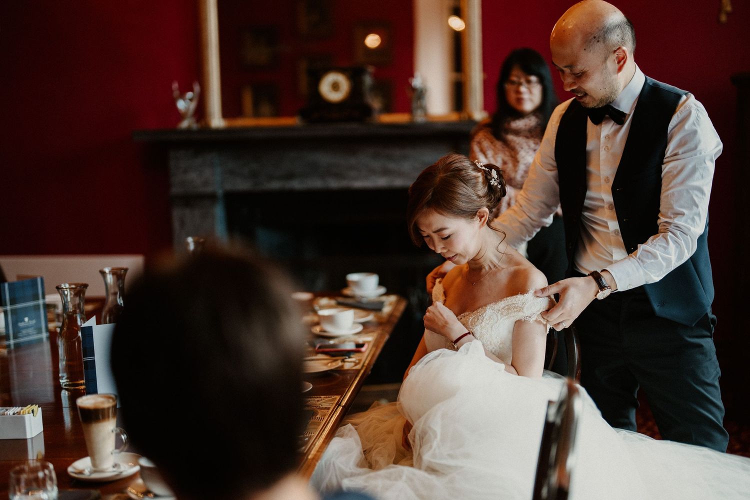 Wedding celebration with guests toasting and sharing drinks in a warm, intimate setting.