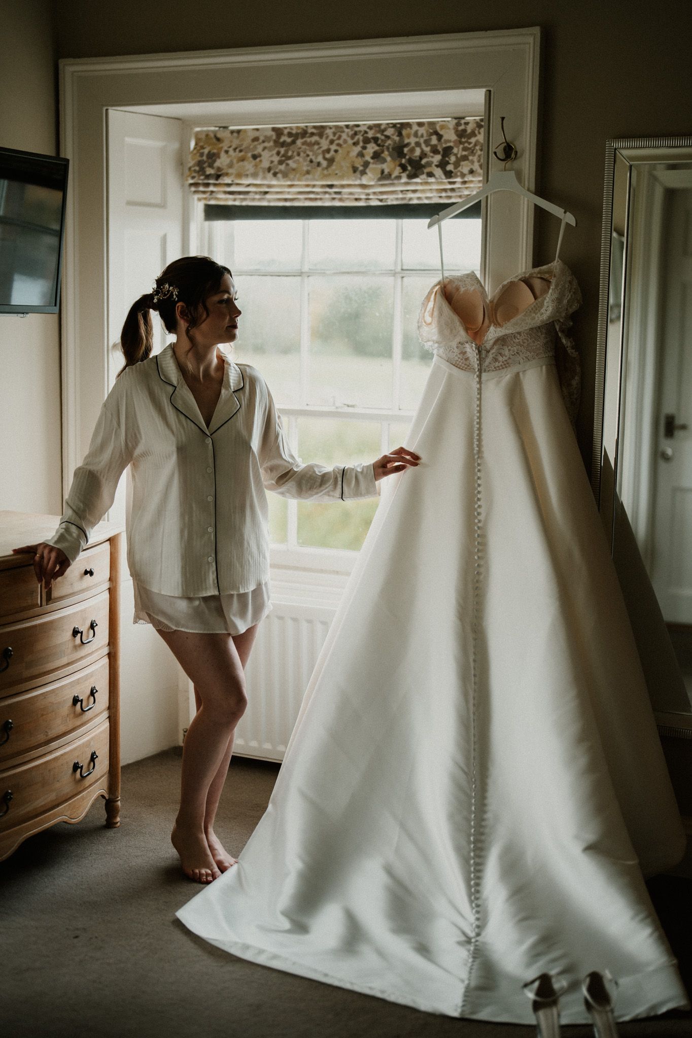 Playful sequence showing someone in a white button-down shirt dancing with a wedding dress on display.