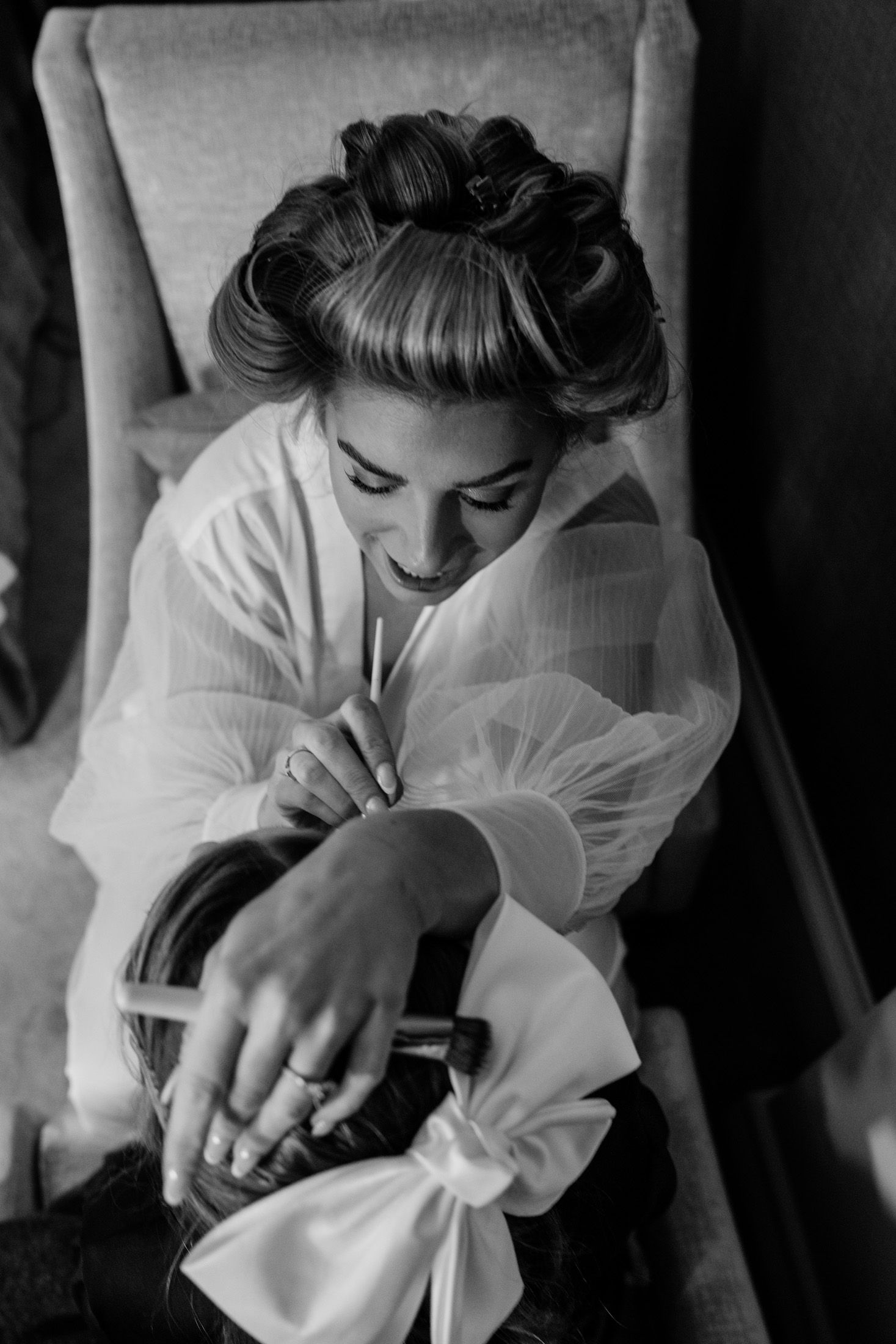 Intimate black and white photo showing preparations in a bridal suite.