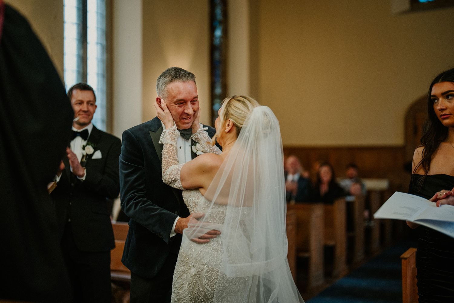A joyful moment captured during a wedding ceremony in a traditional church setting.