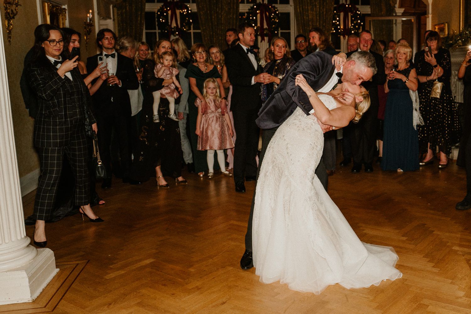 Wedding reception dance floor filled with celebrating guests in an elegant ballroom setting.