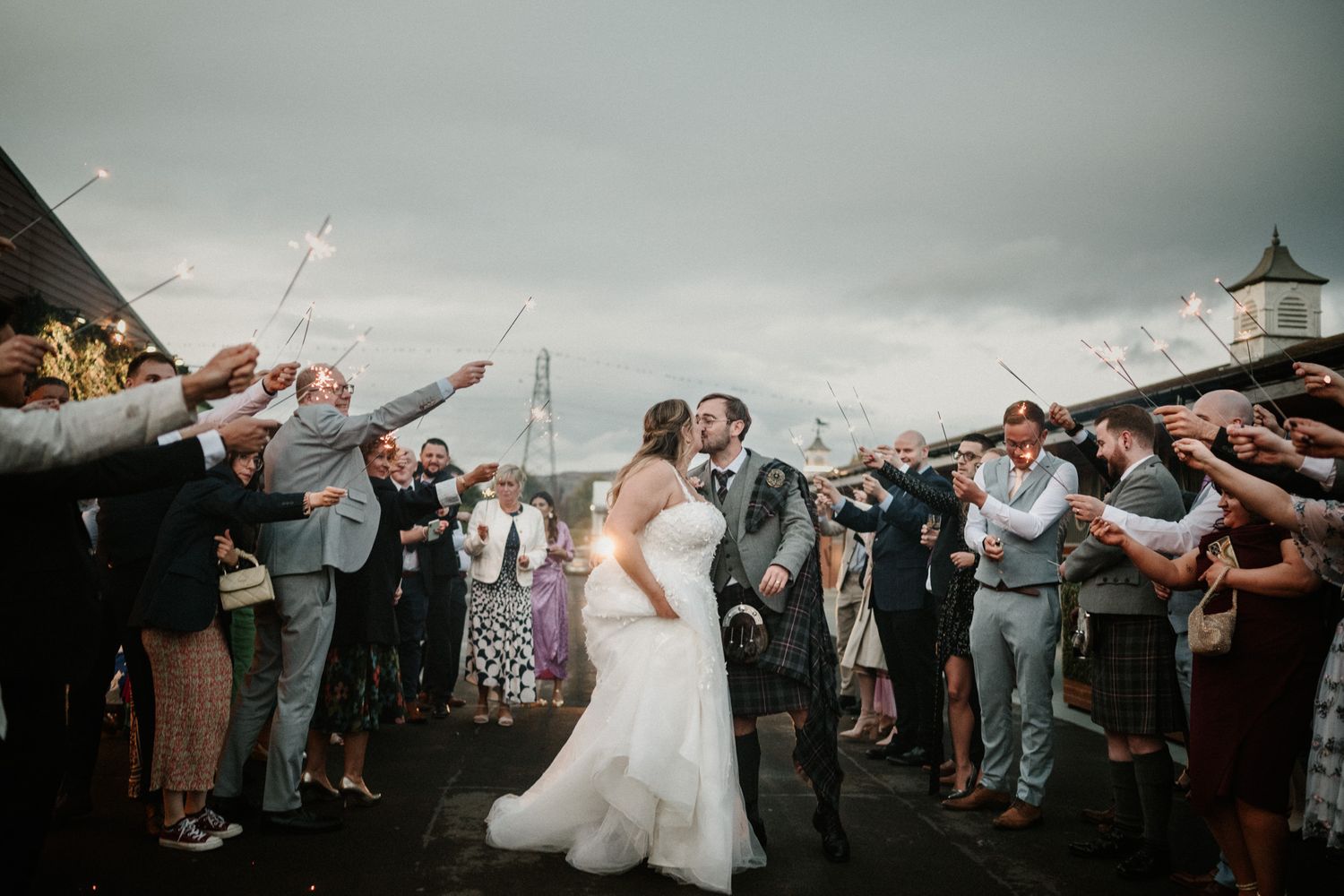 Guests line both sides of walkway throwing confetti during wedding exit celebration.