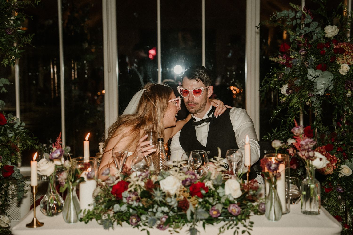 Romantic candlelit wedding reception table with floral arrangements and decorative settings.