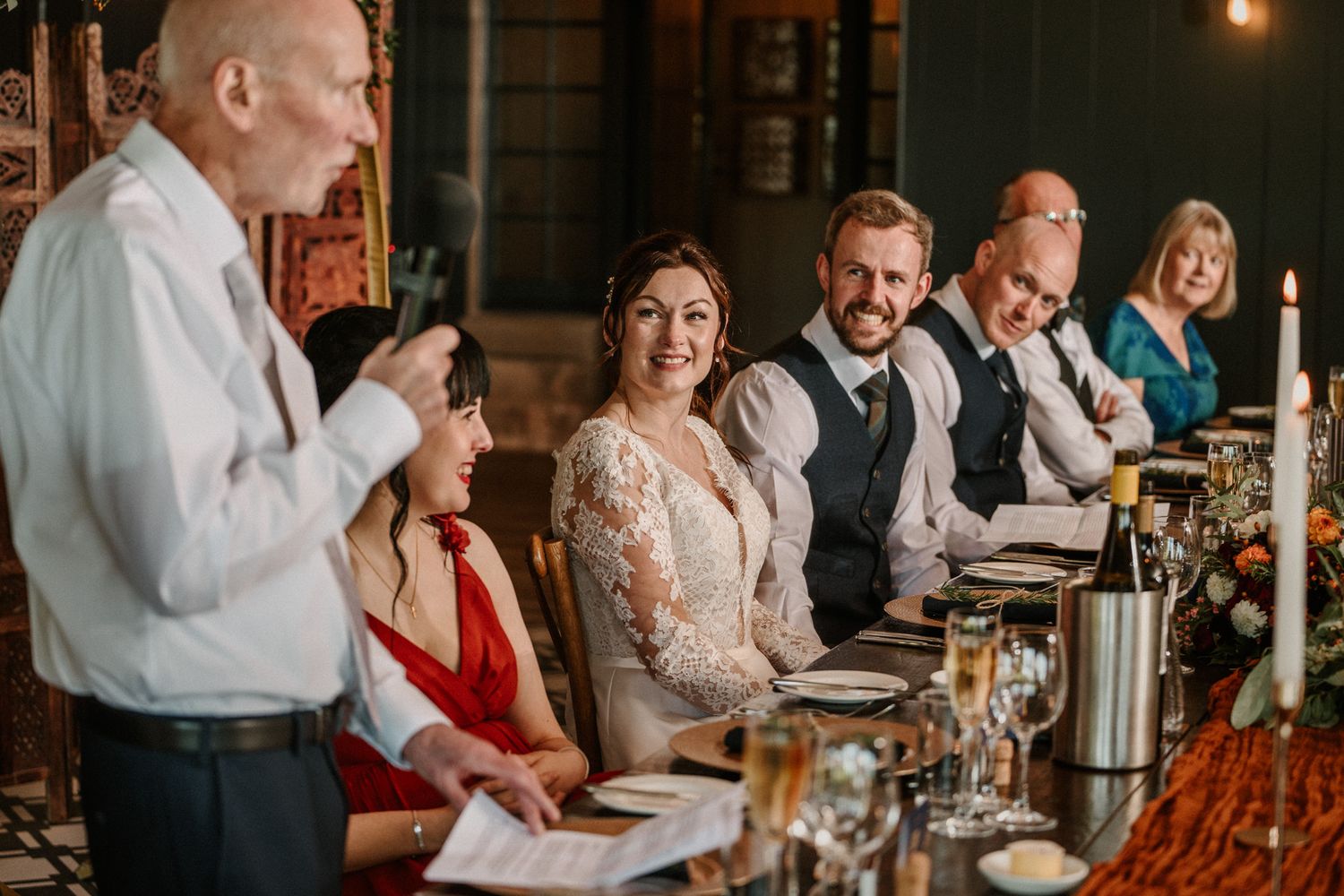 Guests enjoying a formal dinner reception at elegantly set tables with candlelight.