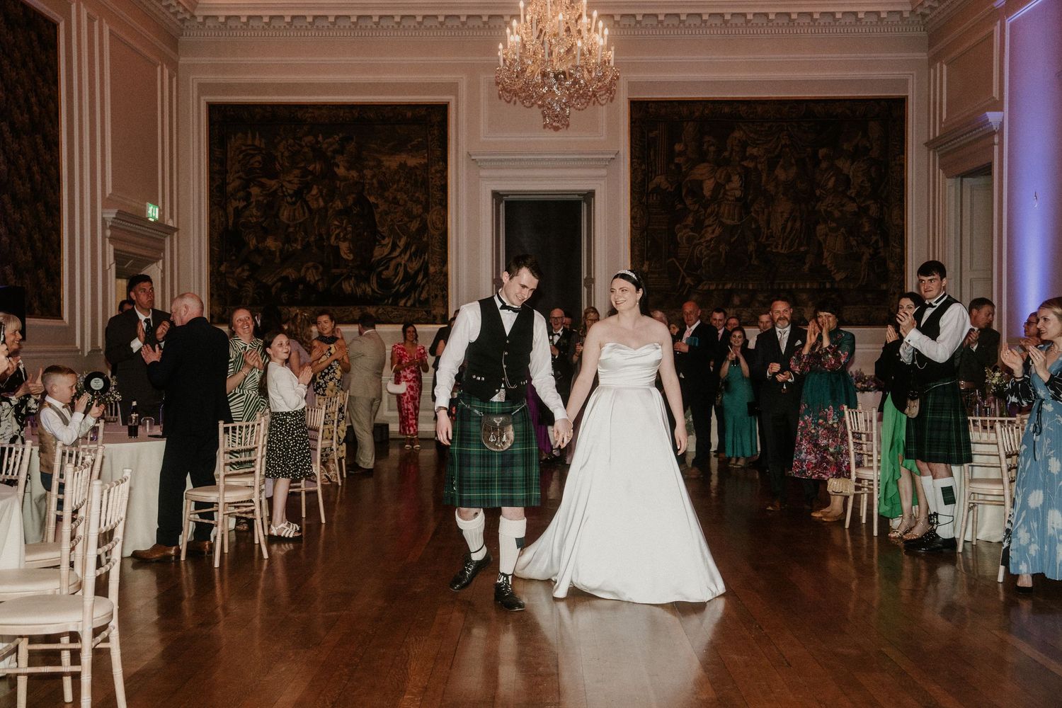 Elegant ballroom wedding reception with crystal chandeliers and classical architectural details.