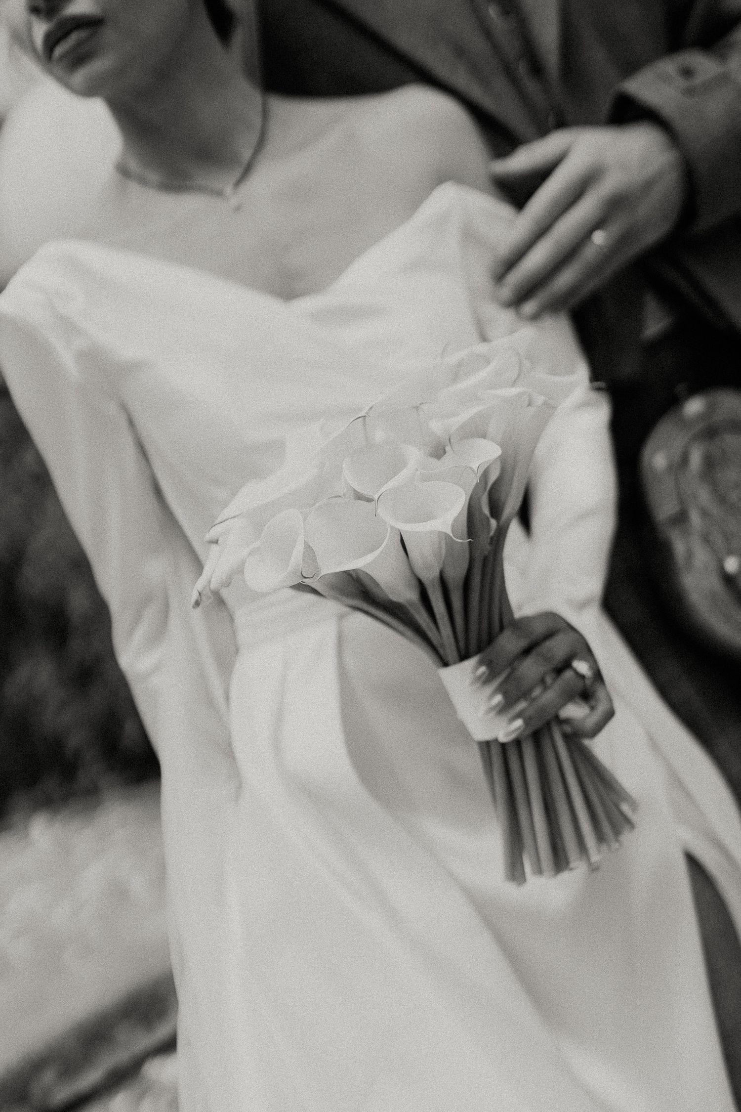 Detail shots of wedding dress and bouquet in elegant black and white photography.