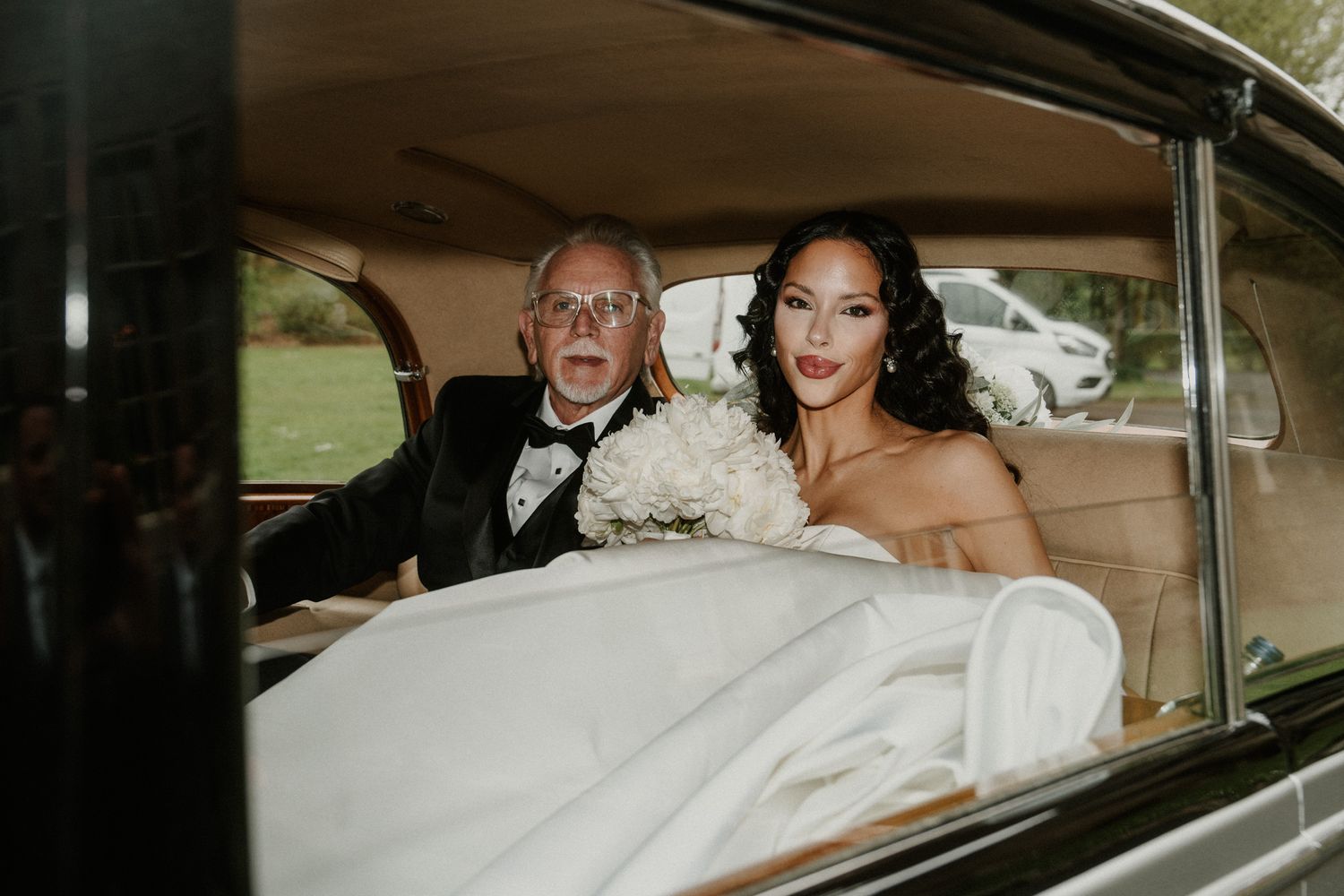 A classic vintage car transports wedding party members on their special day.