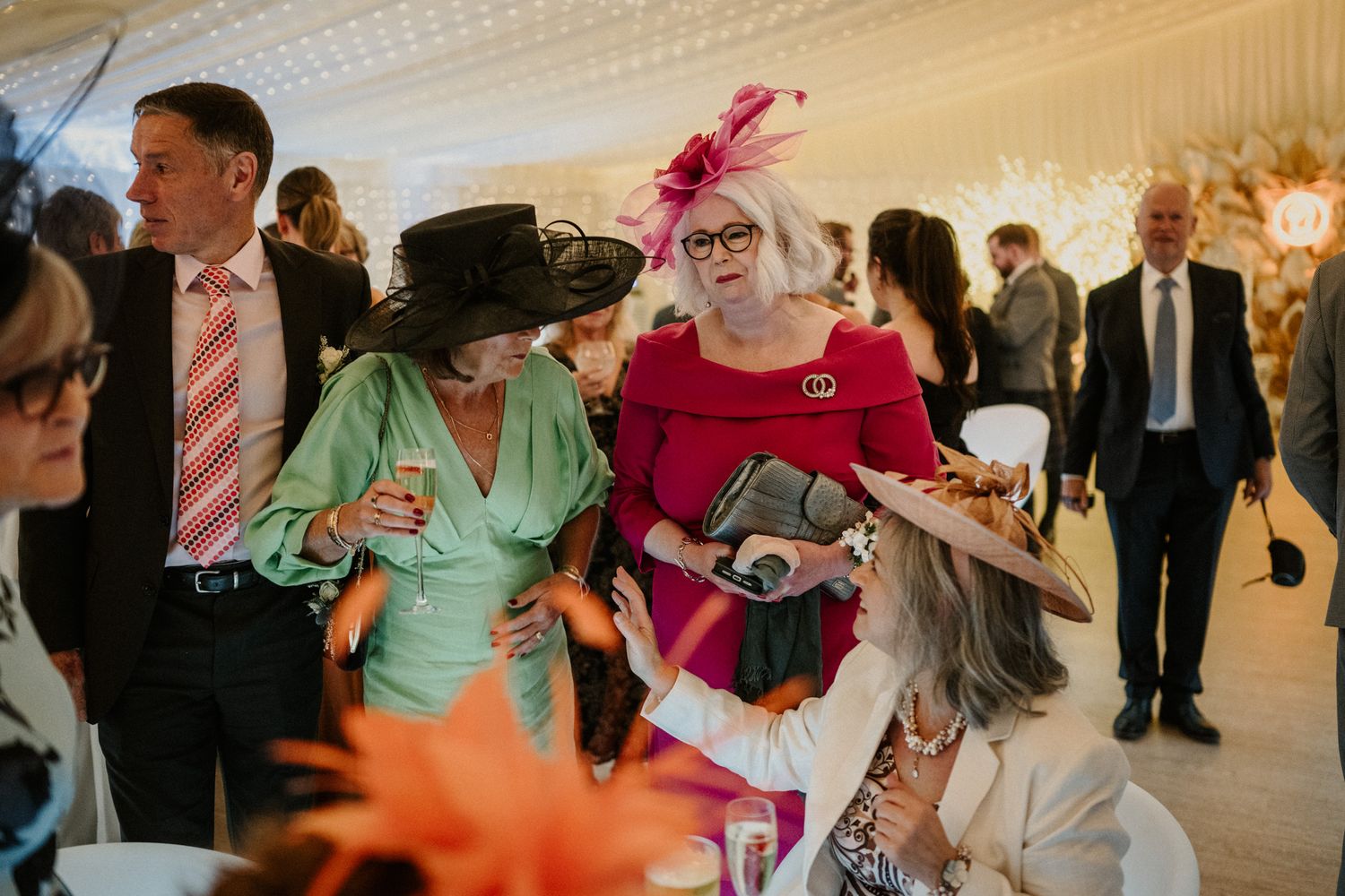 Wedding guests dancing and celebrating in a beautifully decorated reception venue.