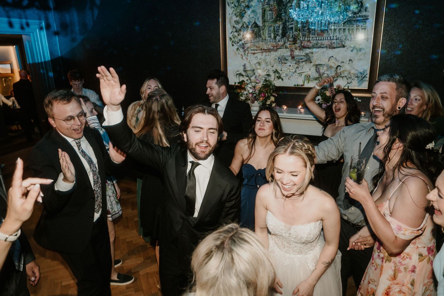 Energetic wedding party guests dancing and having fun at an indoor reception.