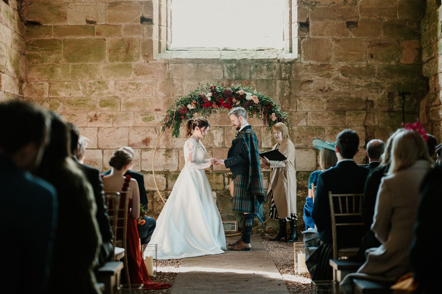 Wedding ceremony space in stone church with natural light and elegant decorations.