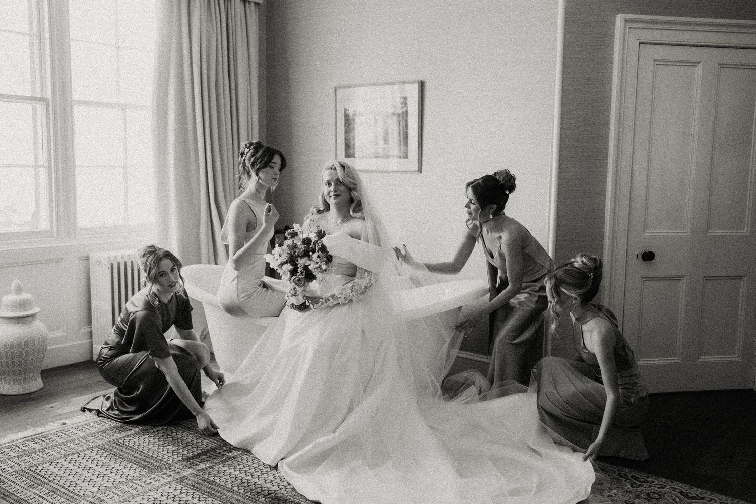 Black and white photos show a bride in a flowing gown posing by a bright window.