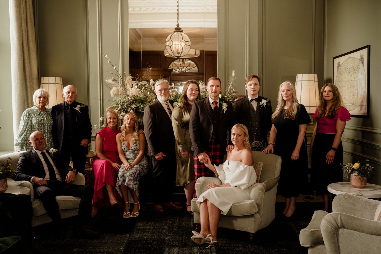 Wedding guests gathered in an ornate room with classic furnishings and decor.