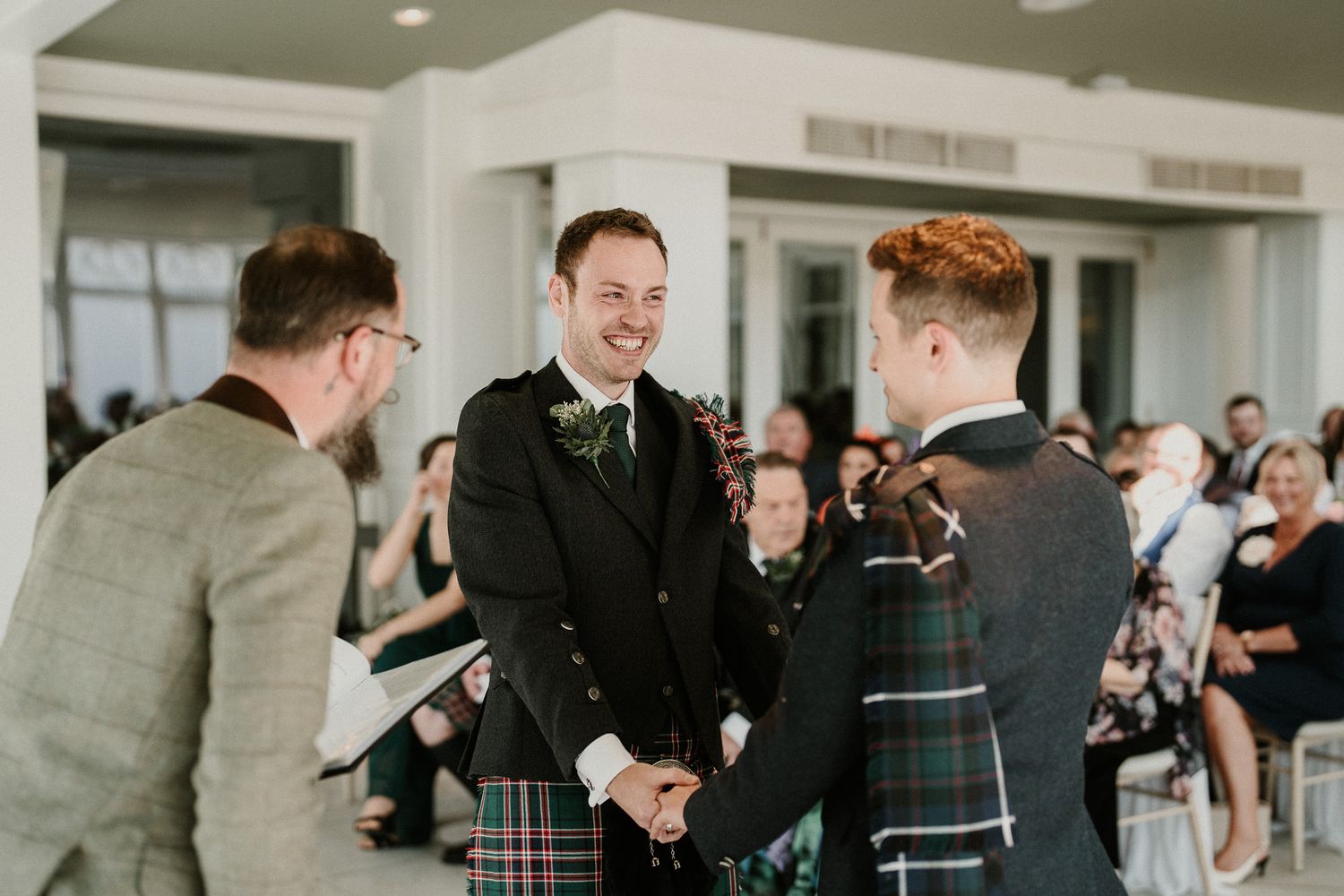 Wedding party members interact in a bright modern reception venue.